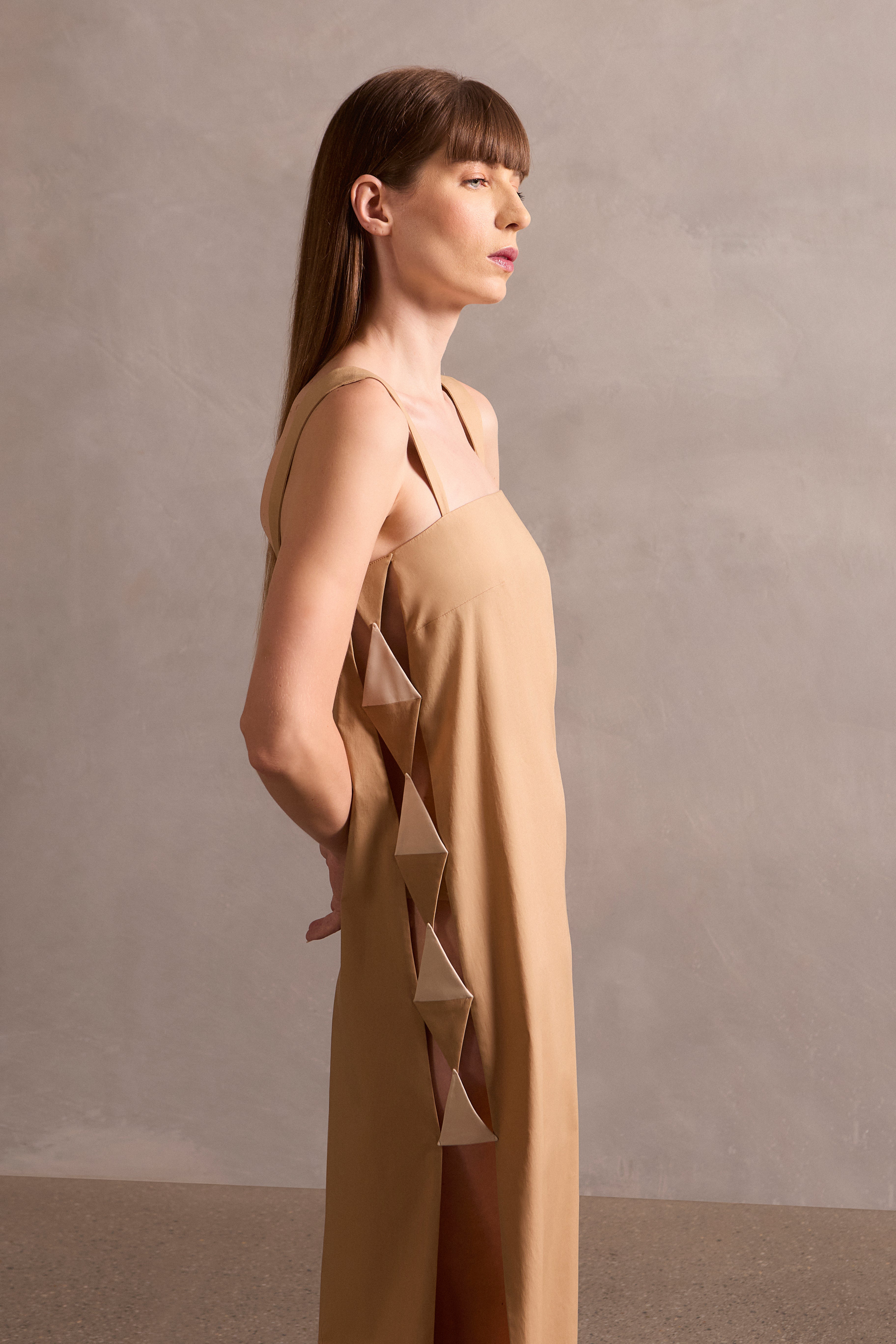 Model wearing the Solid Cut-Out Long Dress Front showcasing its Beige print on 98% Cotton 2% Spandex fabric, styled for an afternoon look.