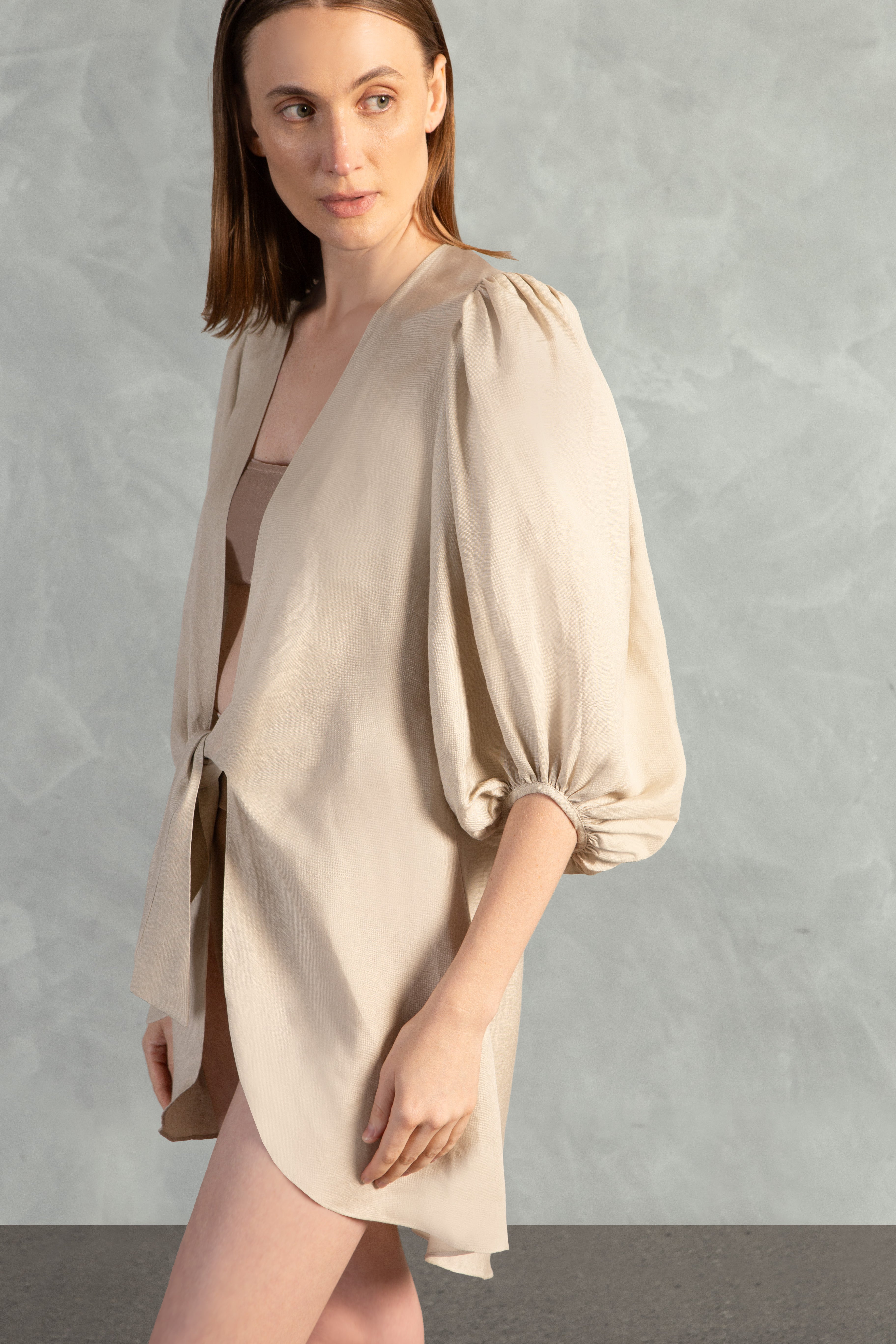 Model wearing the Solid Shirt With Voluminous Sleeves color sand detail with 100% linen fabric, styled for a resort look.