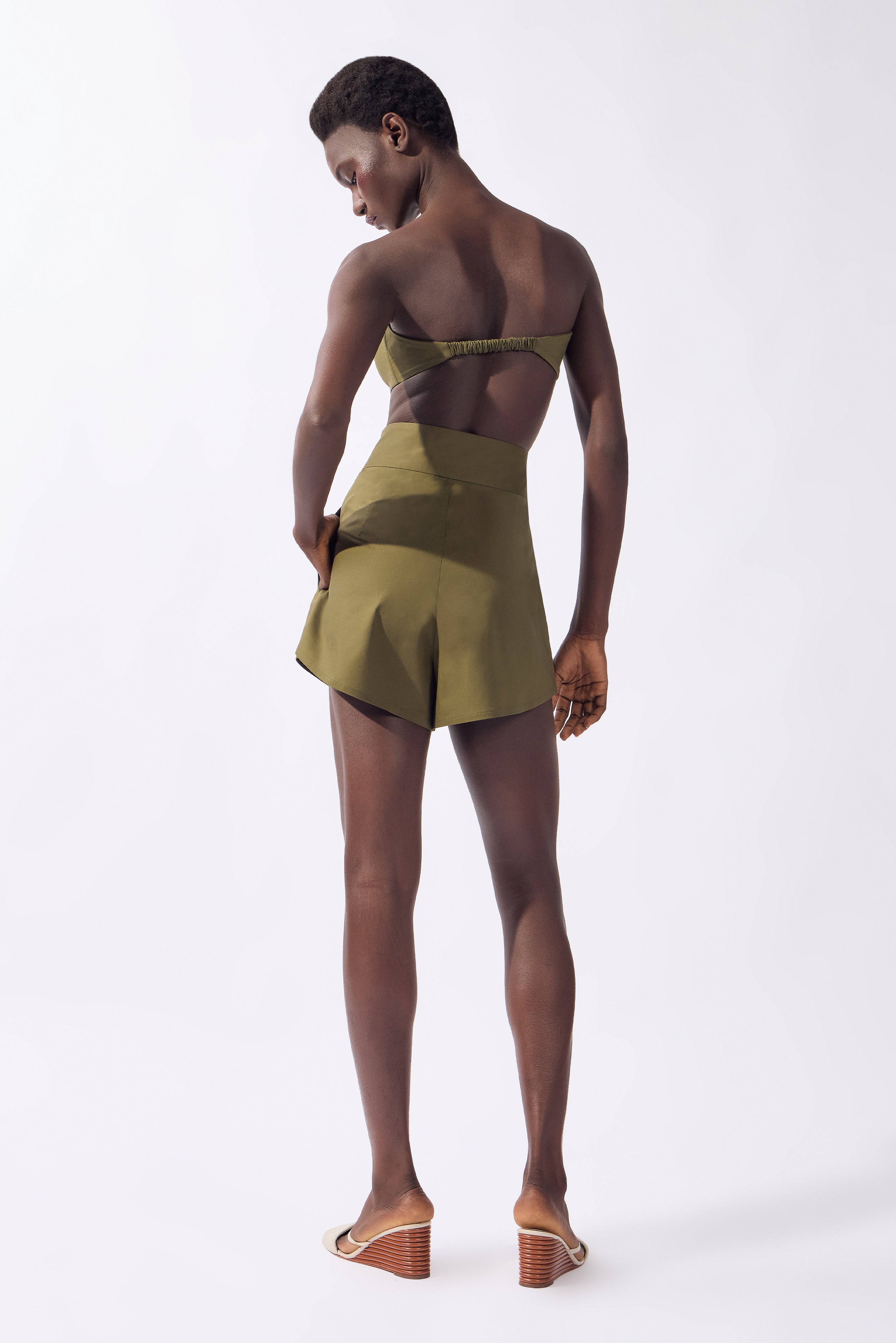 Model wearing the Solid Bandeau Top back color green, made from 98% cotton 2% elastane, styled for a resort look