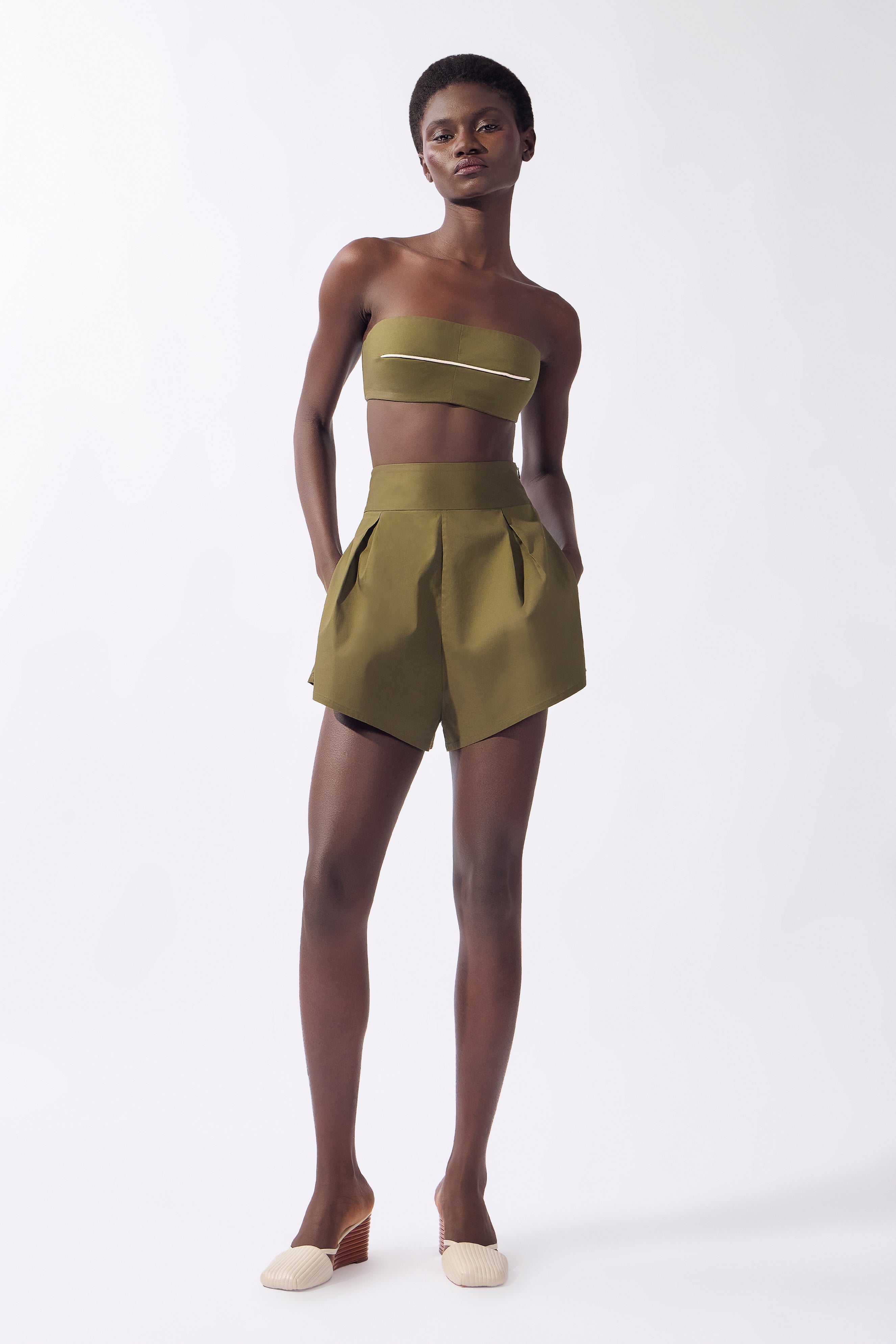 Model wearing the Solid Bandeau Top front color green, made from 98% cotton 2% elastane, styled for a resort look
