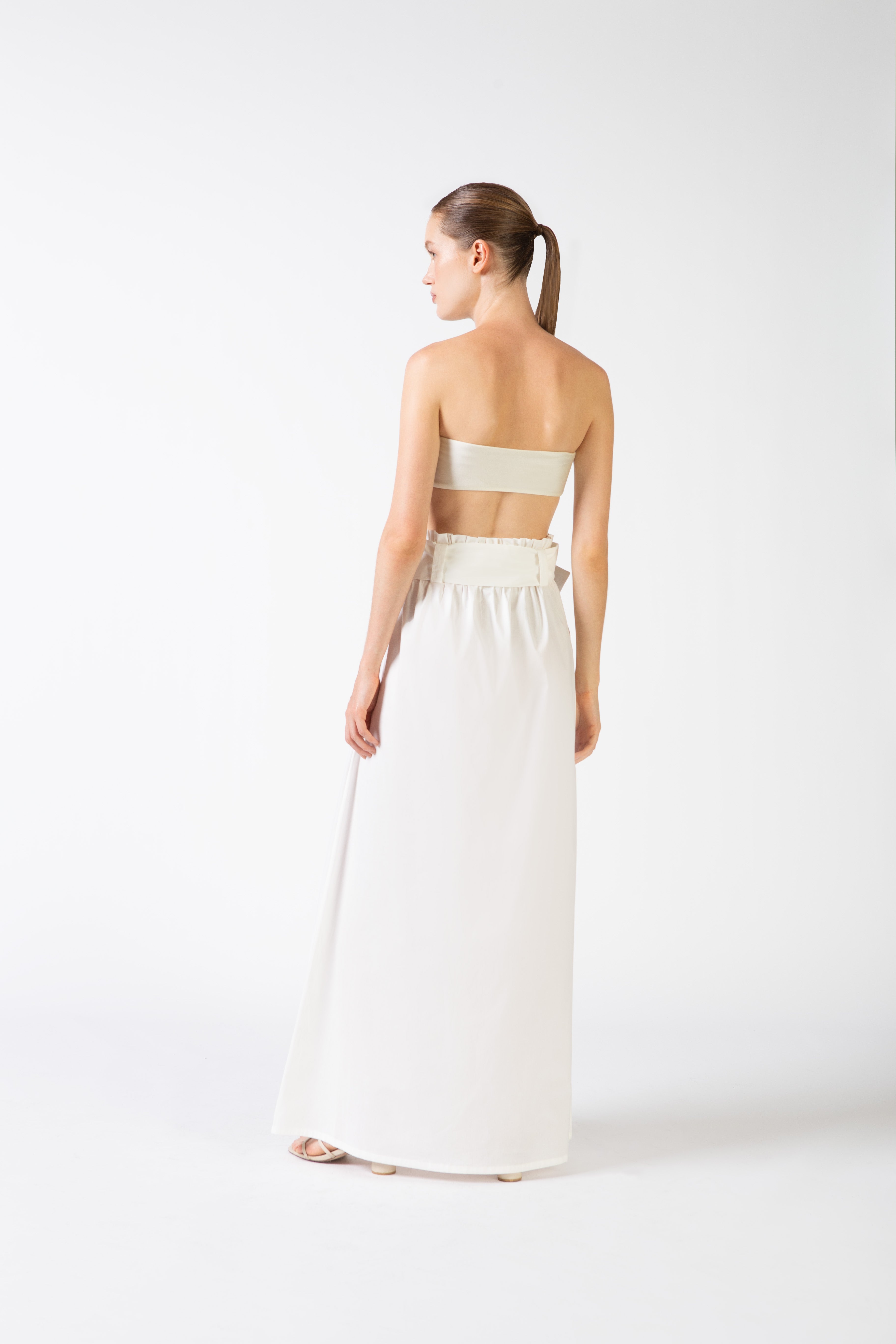 Model wearing the Solid Belted Long Skirt color off white back styled for a resort look.