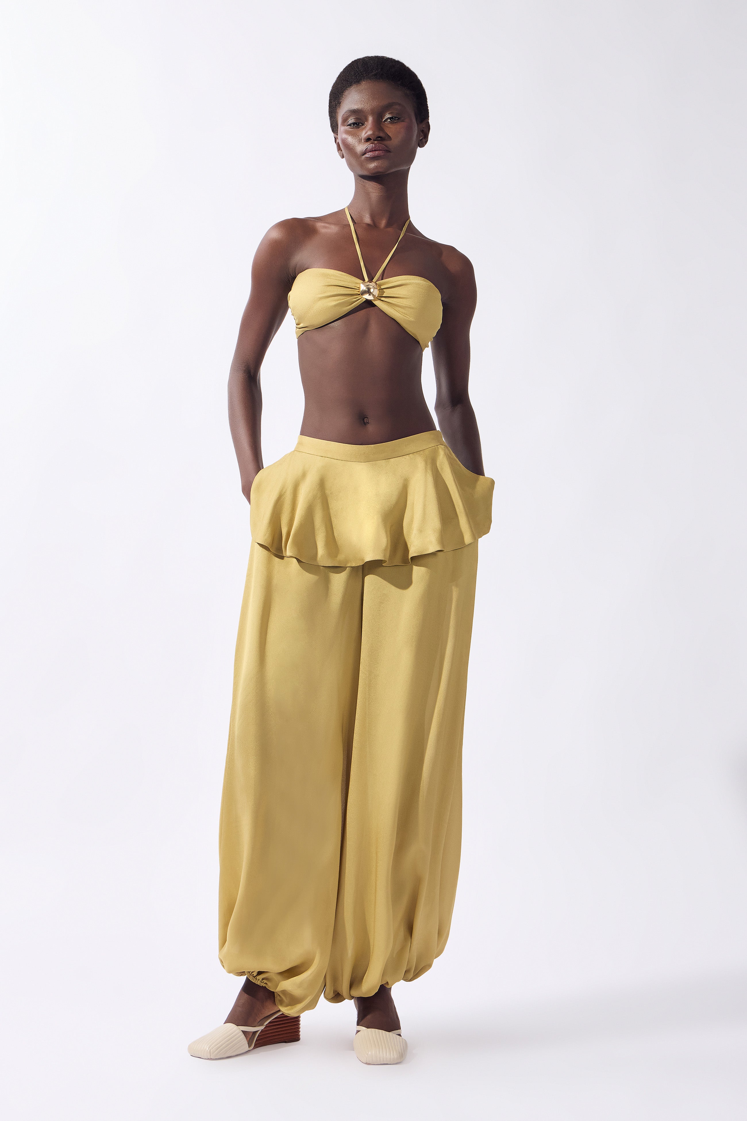 Model wearing the Solid Bubble Pants front color pistachio, made from 100% viscose, styled for an afternoon look