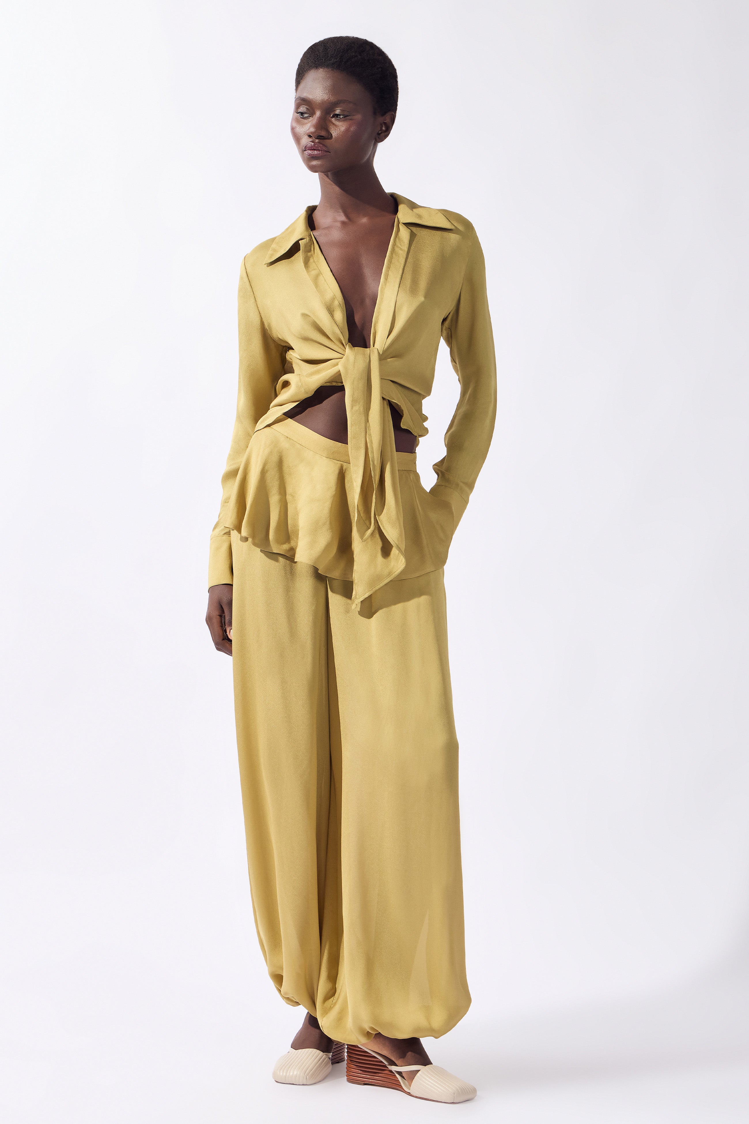 Model wearing the Solid Bubble Pants look color pistachio, made from 100% viscose, styled for an afternoon look