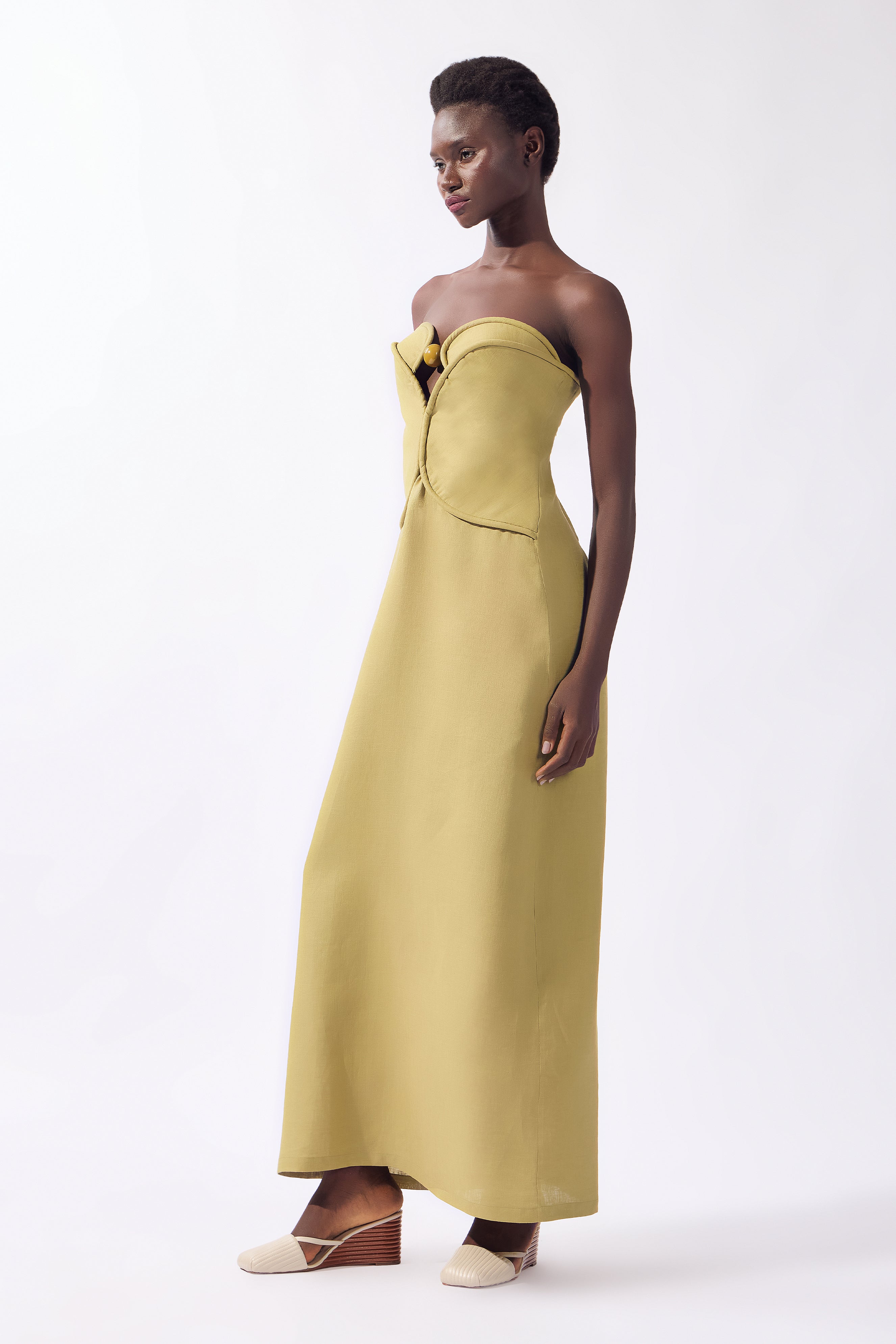 Model wearing the Solid Corset Maxi Dress front color pistachio, made from 100% linen, styled for night look