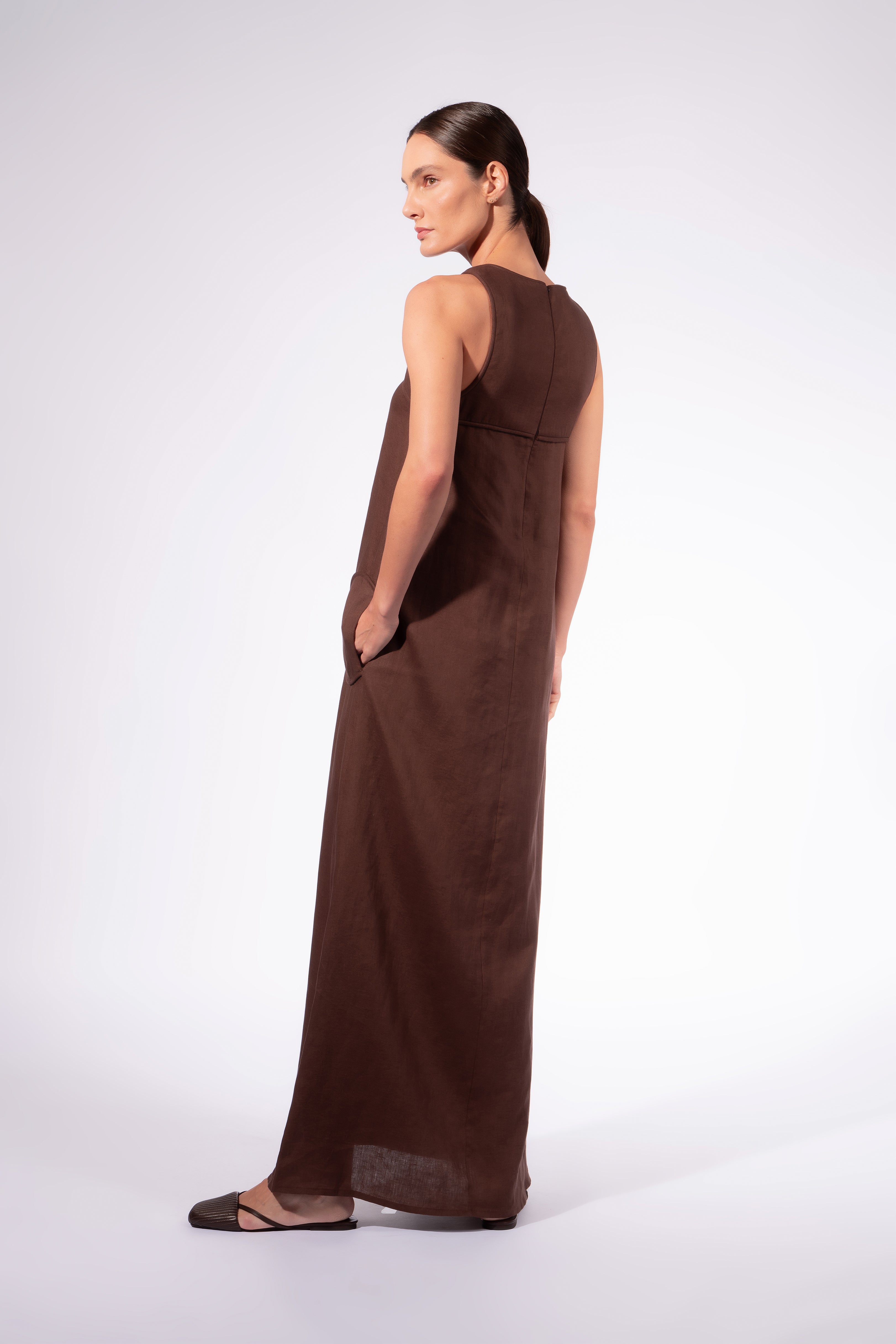 Model waering the Solid Maxi Dress back, showcasing its cocoa 100% viscose fabric, styled for a resort look.