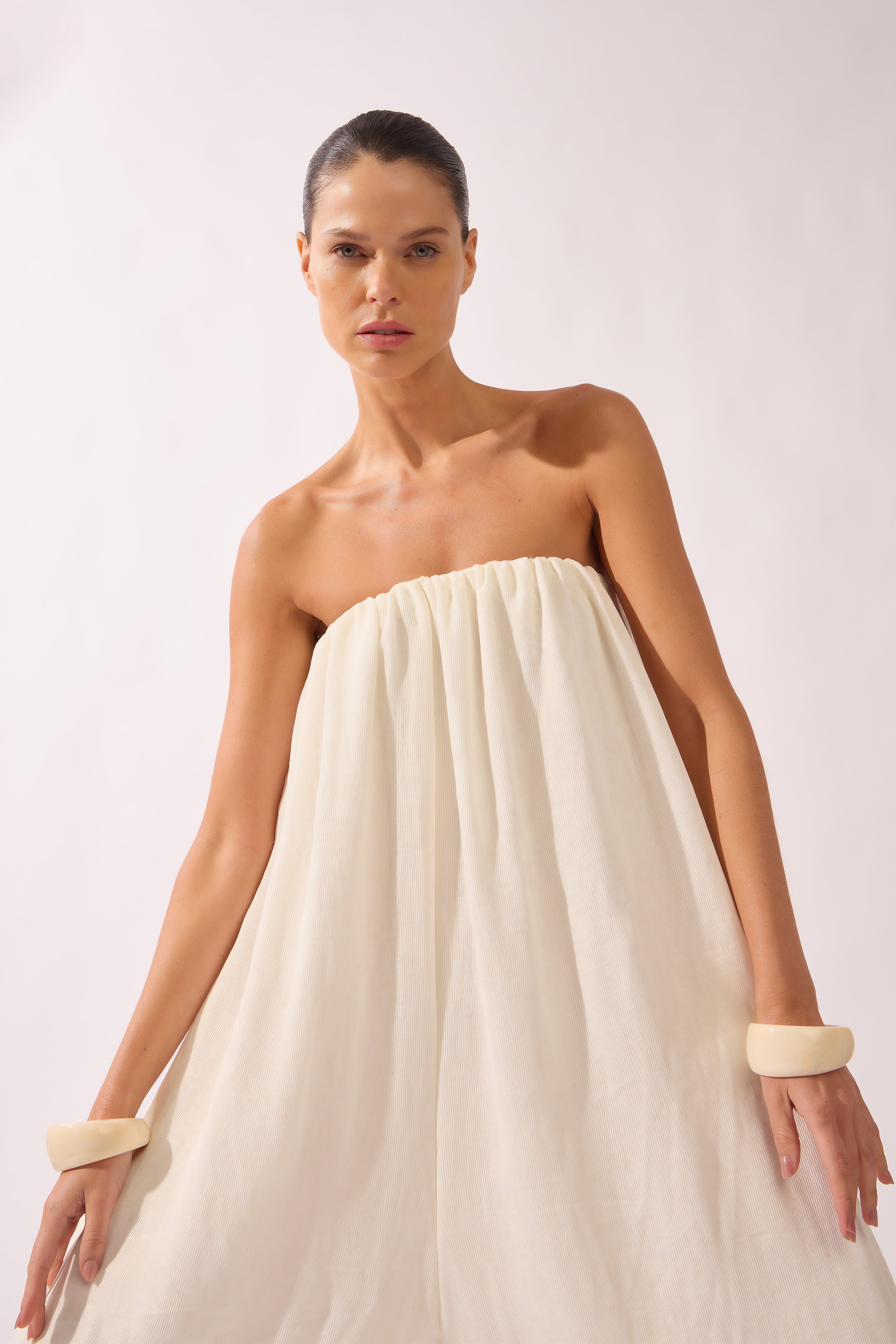 Model waering the Solid Maxi Jampsuit detail, showcasing its off-white 70% Viscose 17% Polyamide 13% Linen fabric, styled for a resort look.