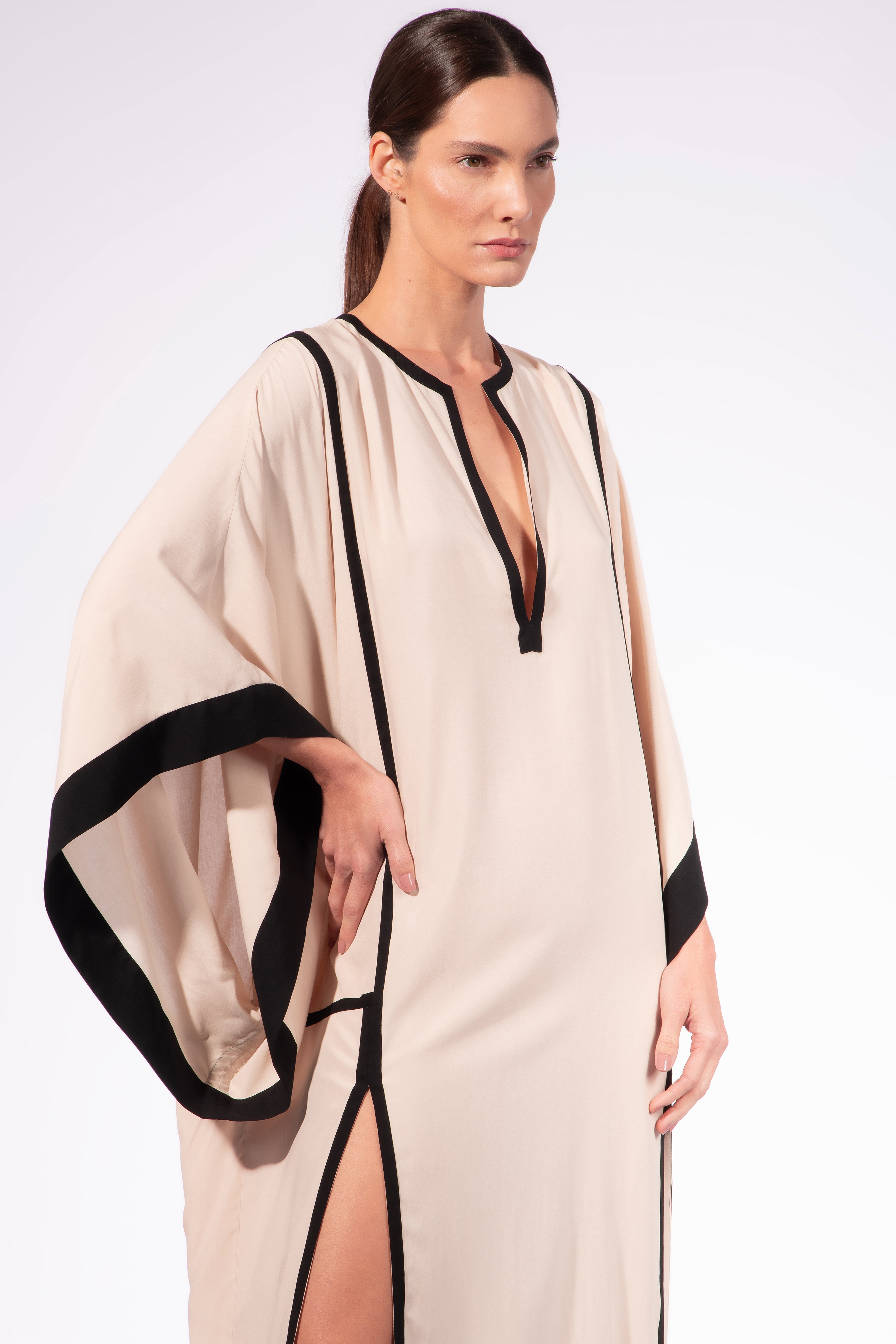Model waering the Solid Maxi Kaftan detail, showcasing its off-white 100% viscose fabric, styled for a resort look.