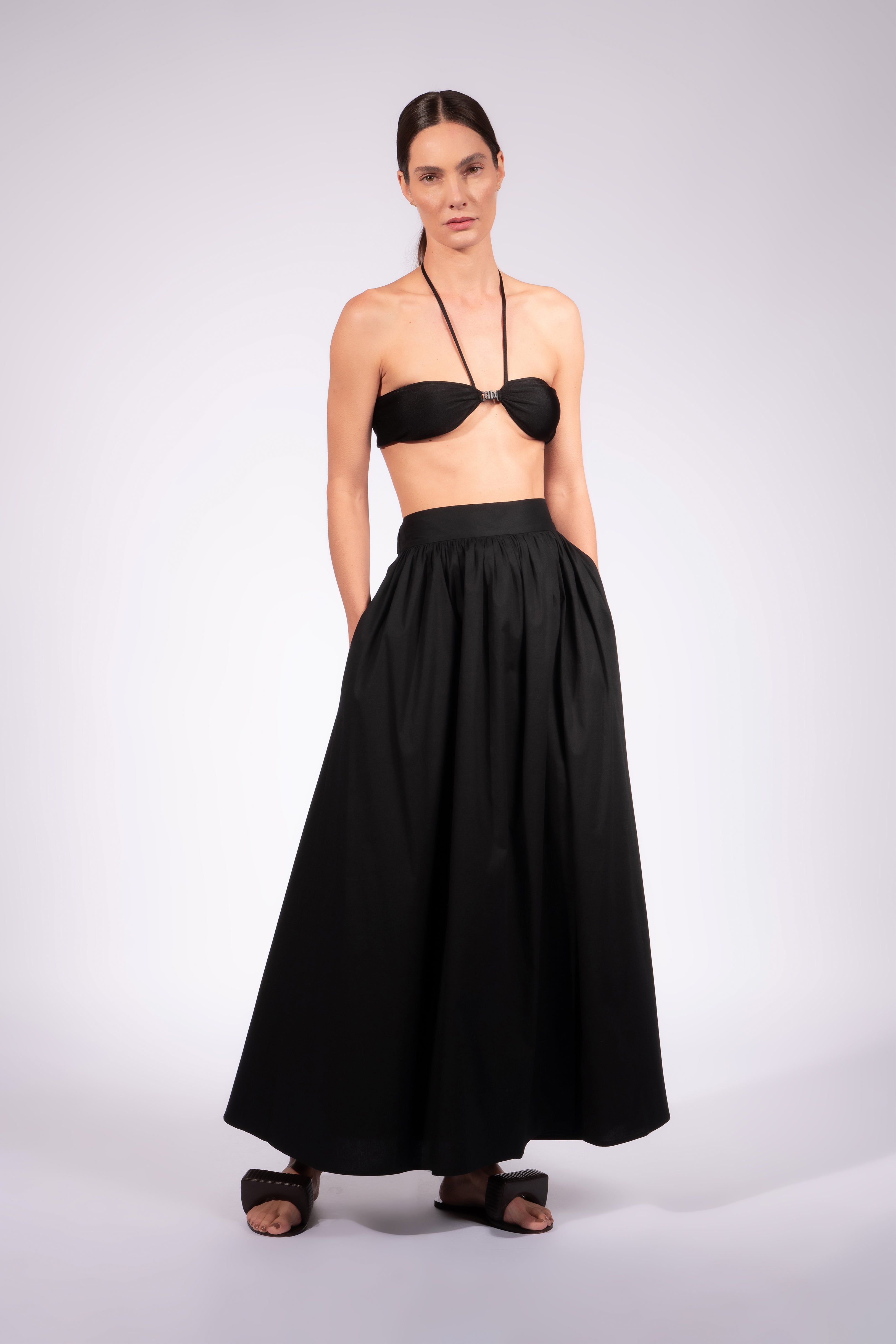 Model wearing the Solid Maxi Skirt front front color black made with 98% Cotton 2% Elastane, styled for resortwear look