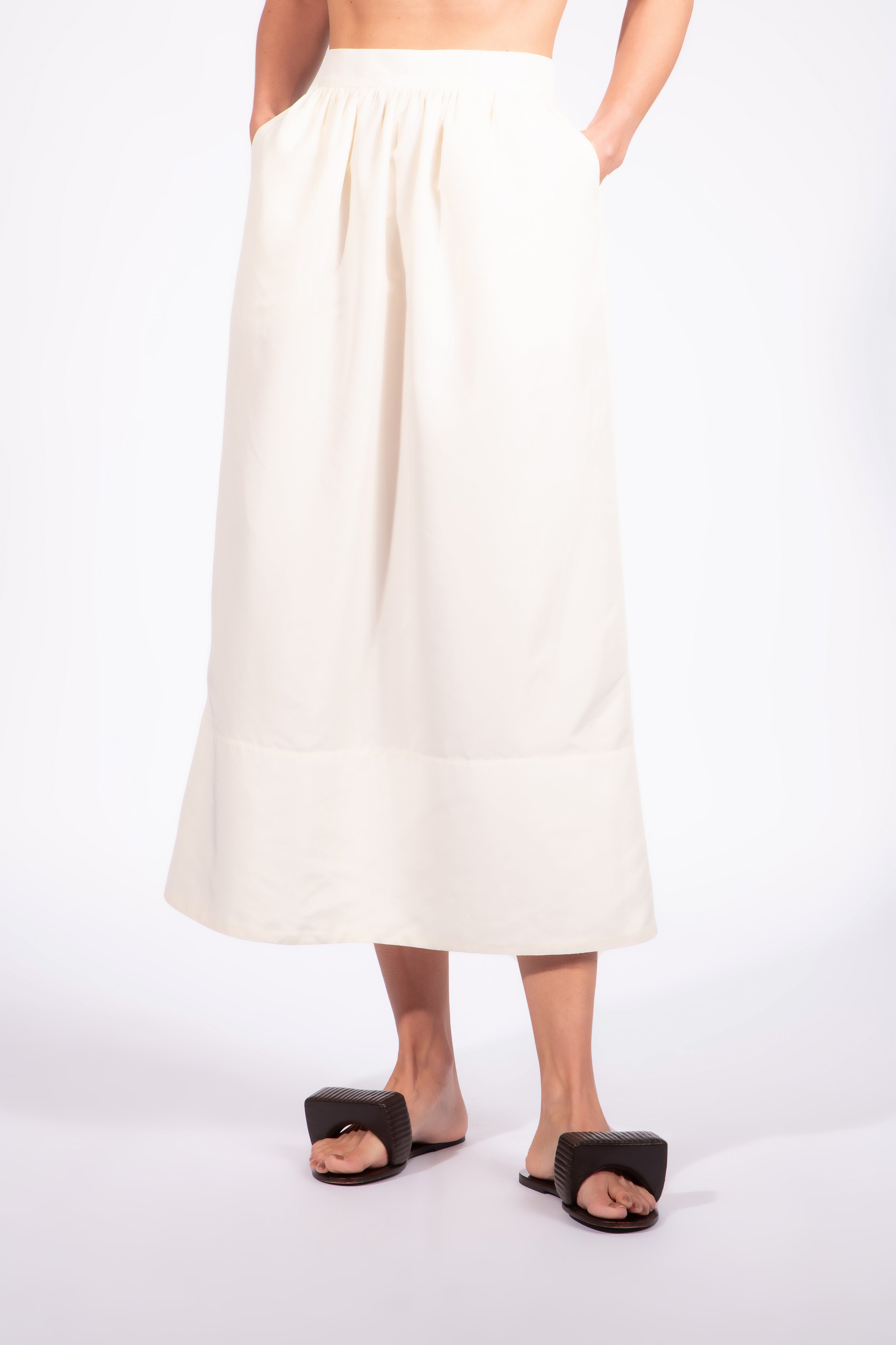 Model wearing the Solid Maxi Skirt detail color off white, made from 92% polyester 07% elastane, styled for a dinner look