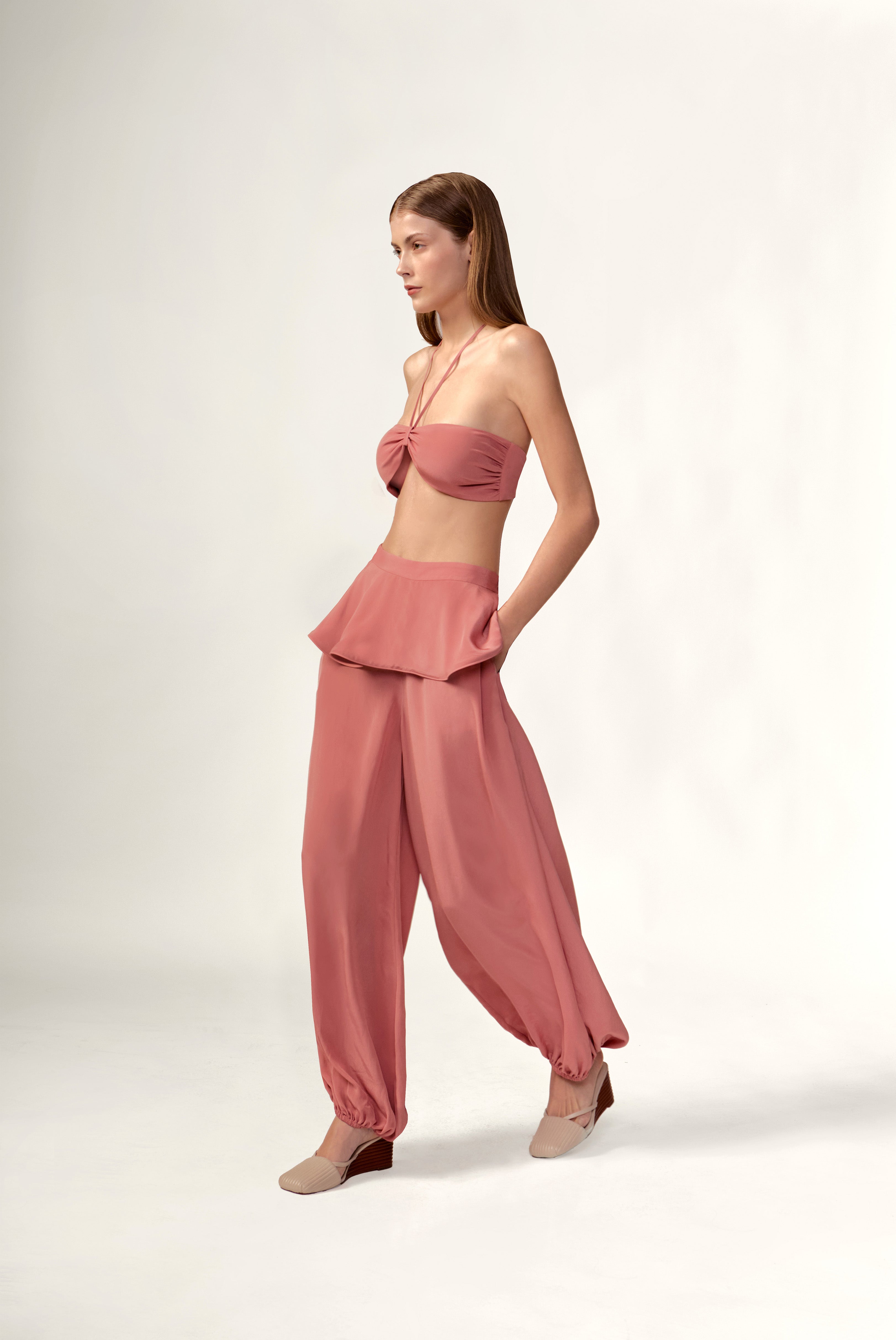 Model wearing the Solid Peplum Maxi Pants look color vintage rose, made with 100% viscose, styled for resortwear look