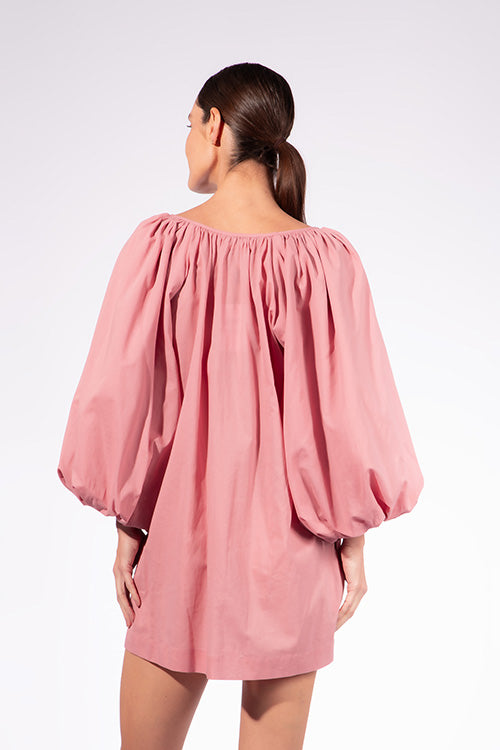 Model wearing the Solid Puff Sleeve Mini Dress back color pink made with 97% Cotton 3% Elastane, styled for resortwear look