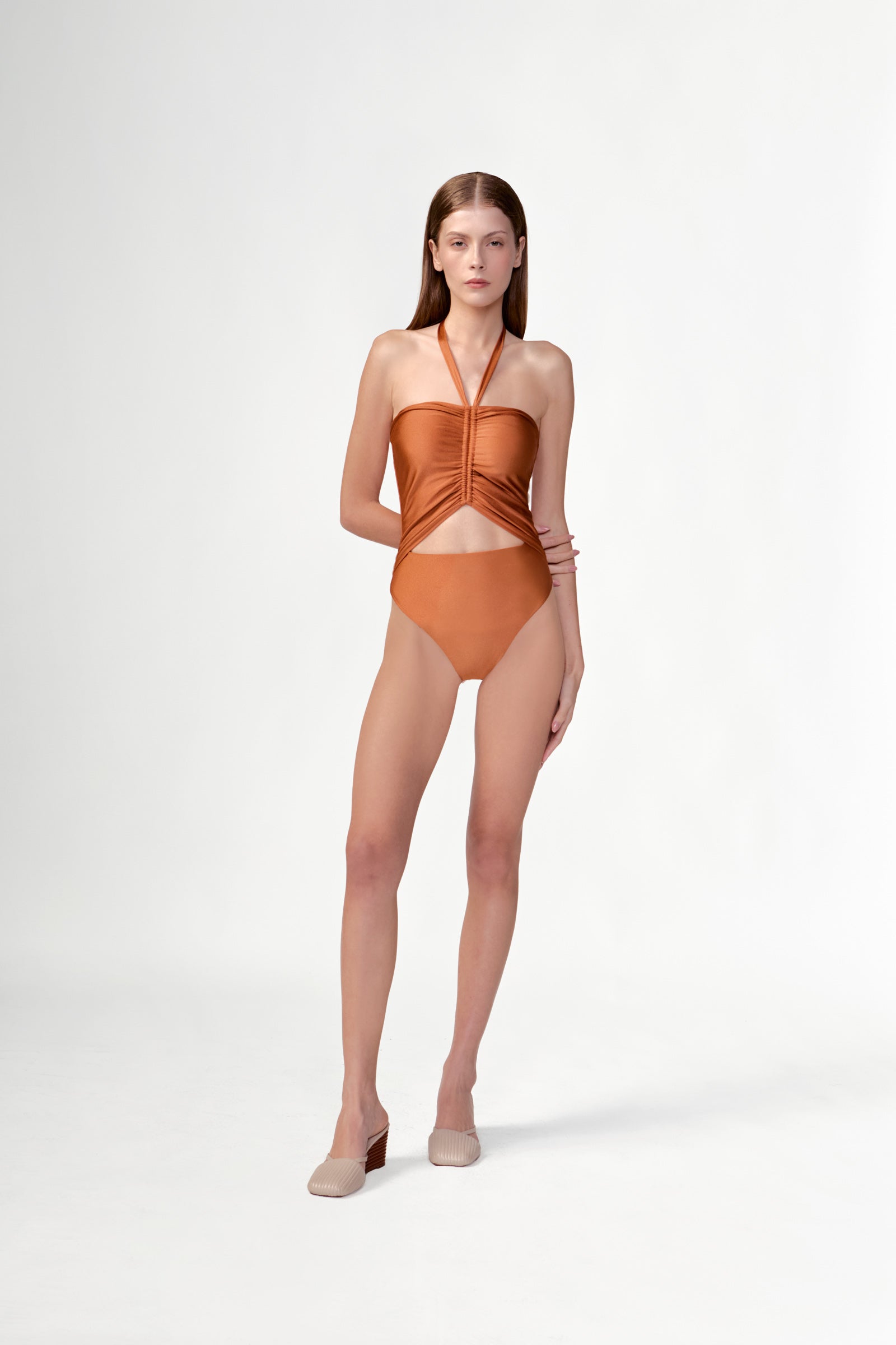 Model wearing the Solid Ruched Swimsuit front color cognac, made from 85% plyamide 15% elastane, styled for a beachwear look