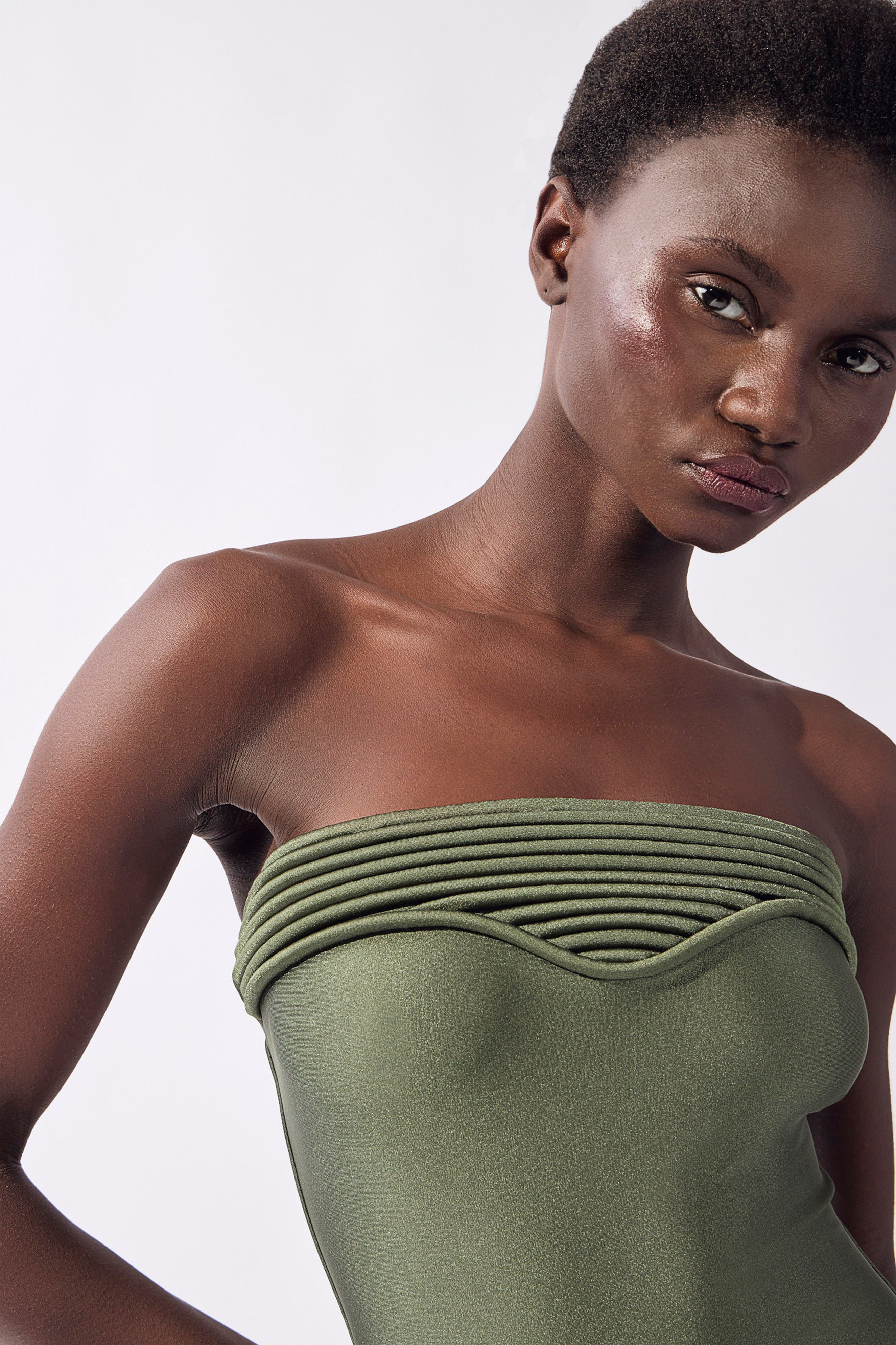 Model wearing the Strapless Swimsuit detail color olive, made from 85% polyester 15% elastane, styled for beachwear look