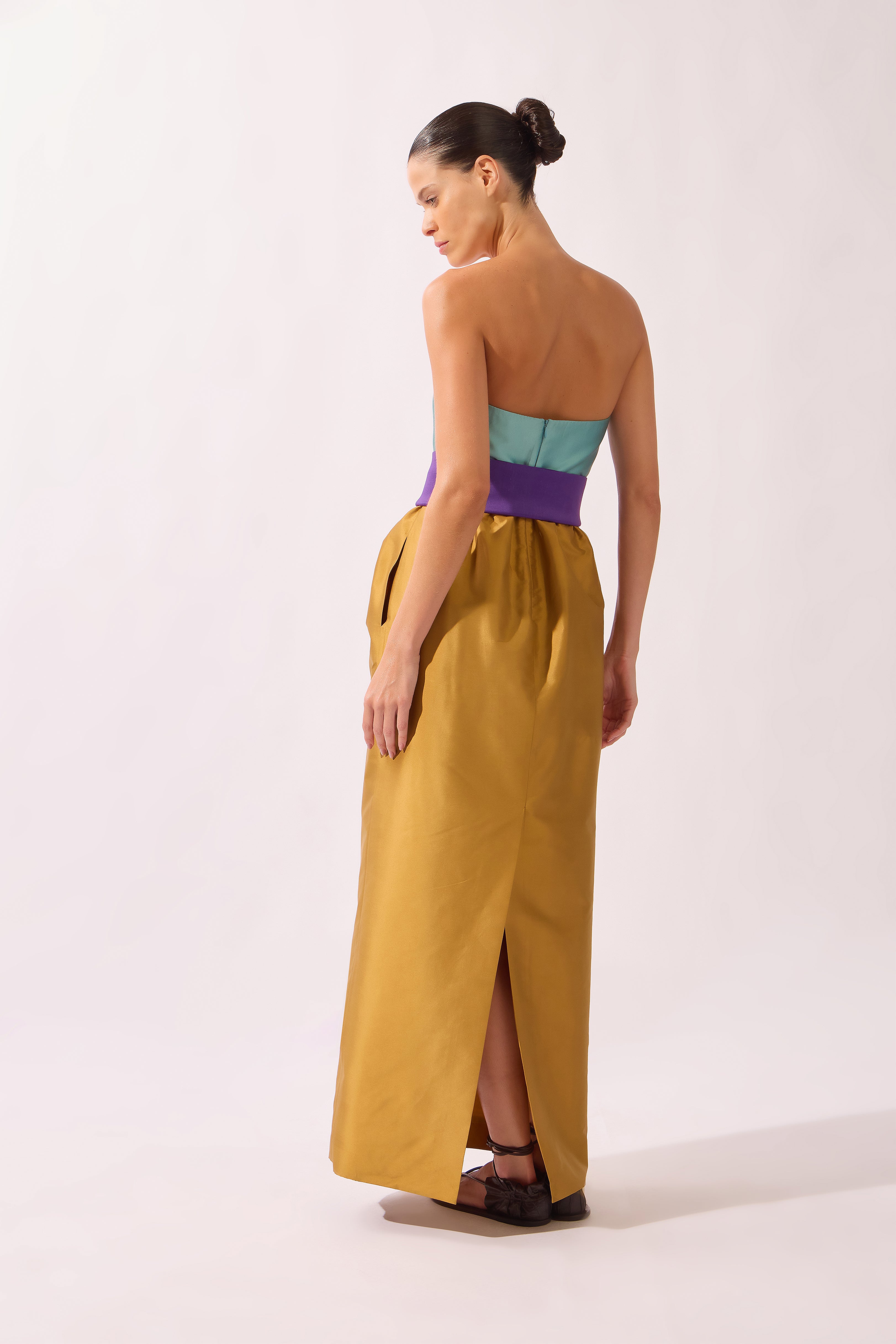 Model wearing the Structured Maxi Dress back color ochre made with 100% polyetser, styled for an evening look