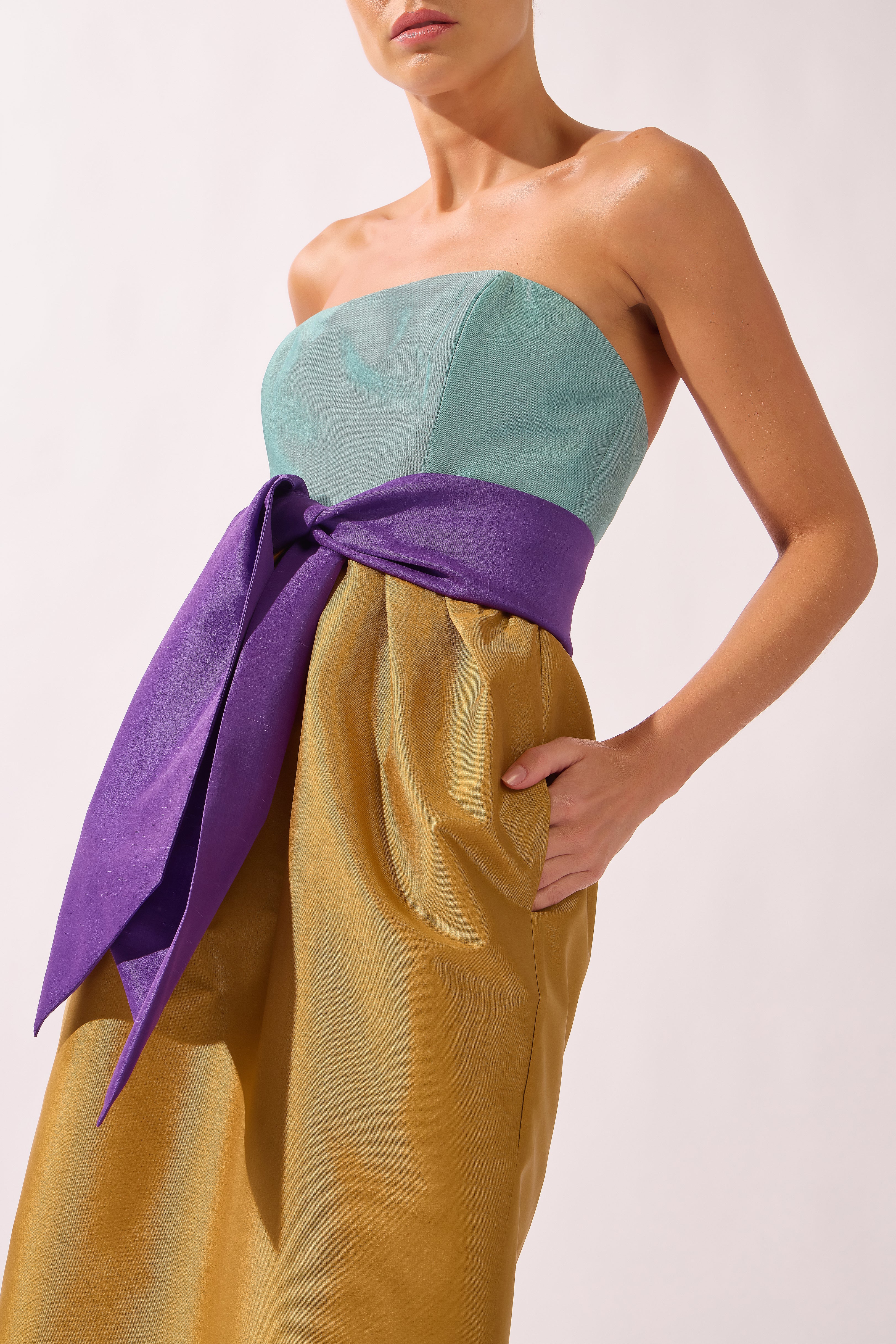 Model wearing the Structured Maxi Dress detail color ochre made with 100% polyetser, styled for an evening look