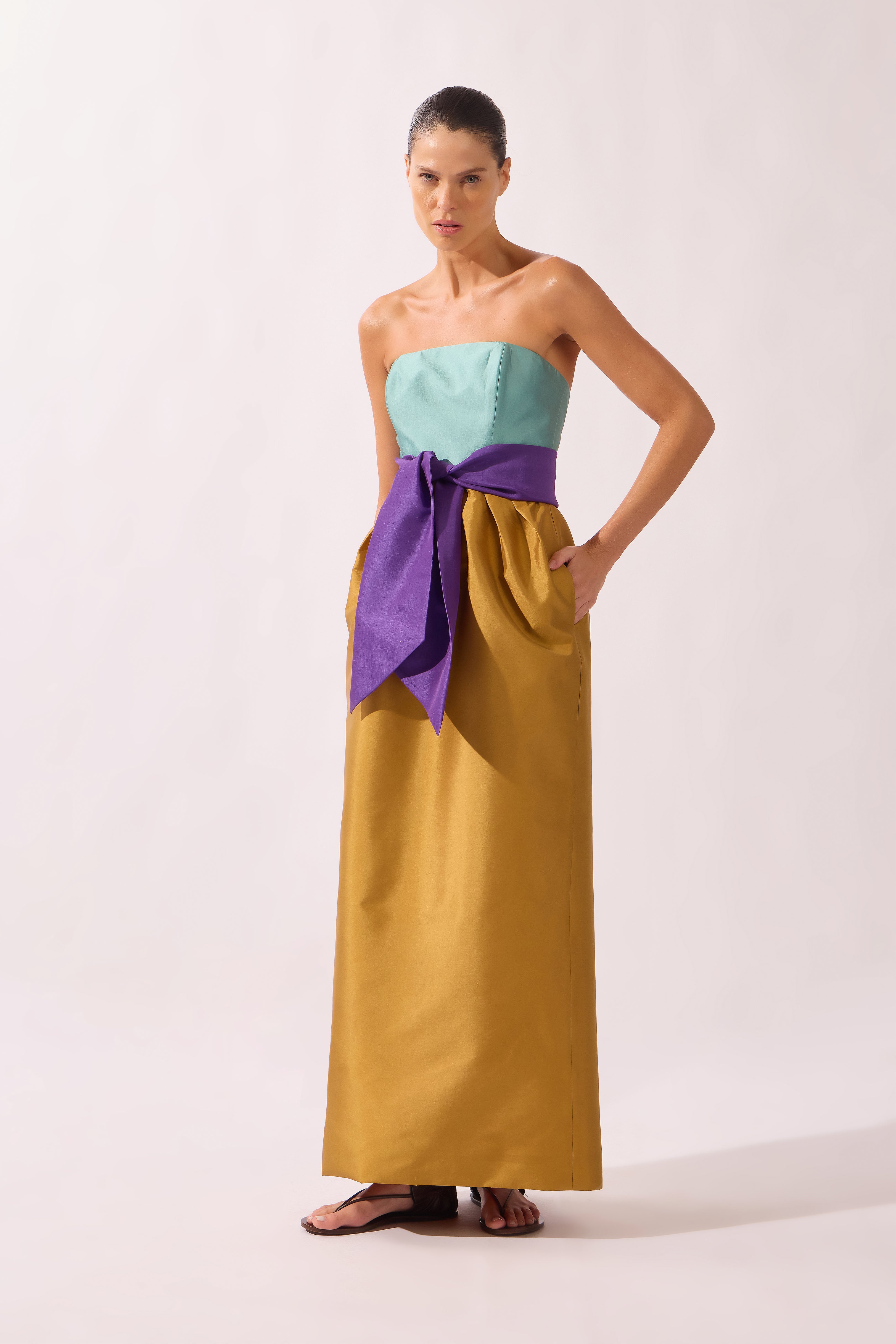 Model wearing the Structured Maxi Dress front color ochre made with 100% polyetser, styled for an evening look