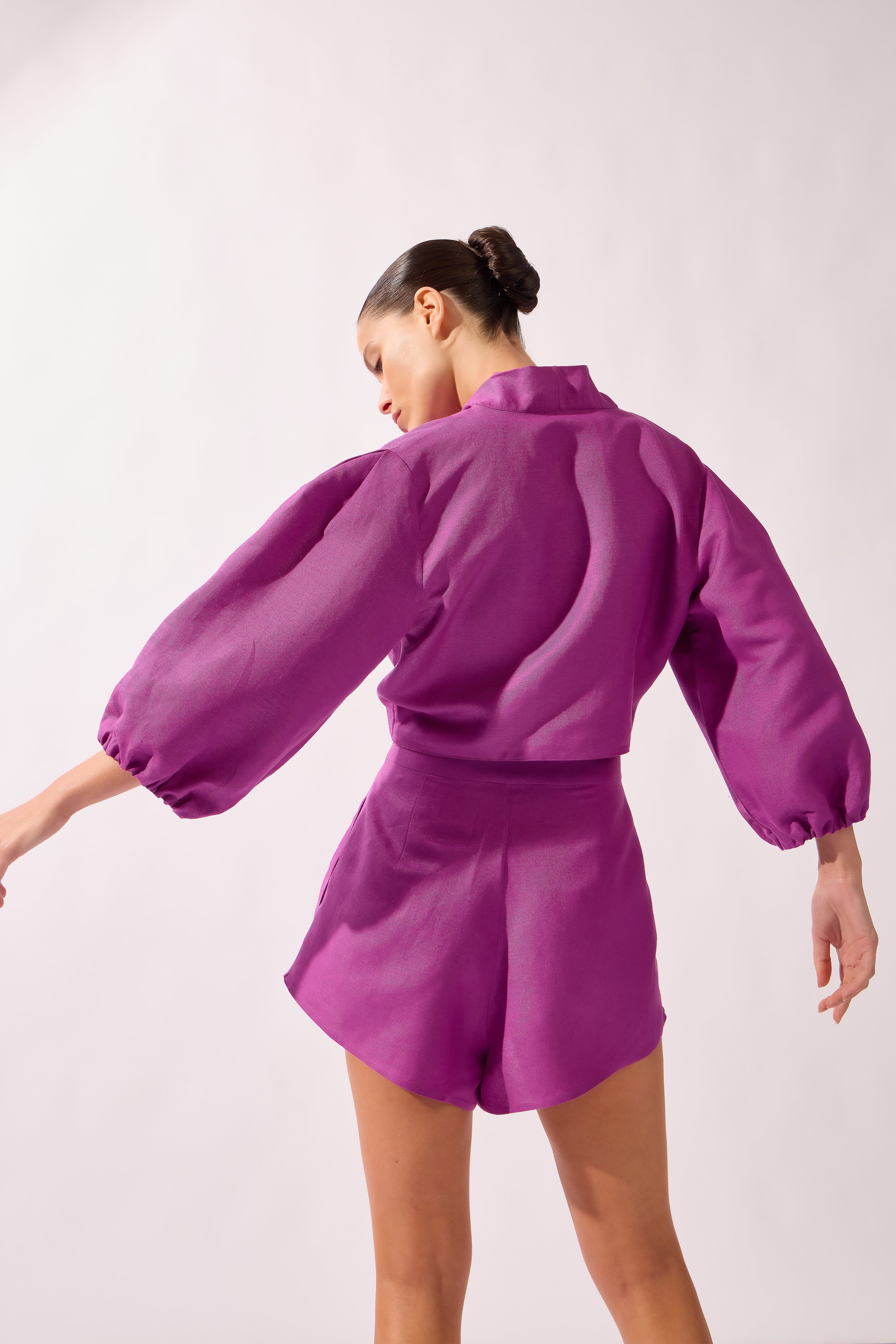 Model wearing the Tie-Front Crop Top back color purple, made from 55% linen 45% viscose, styled for a resort look