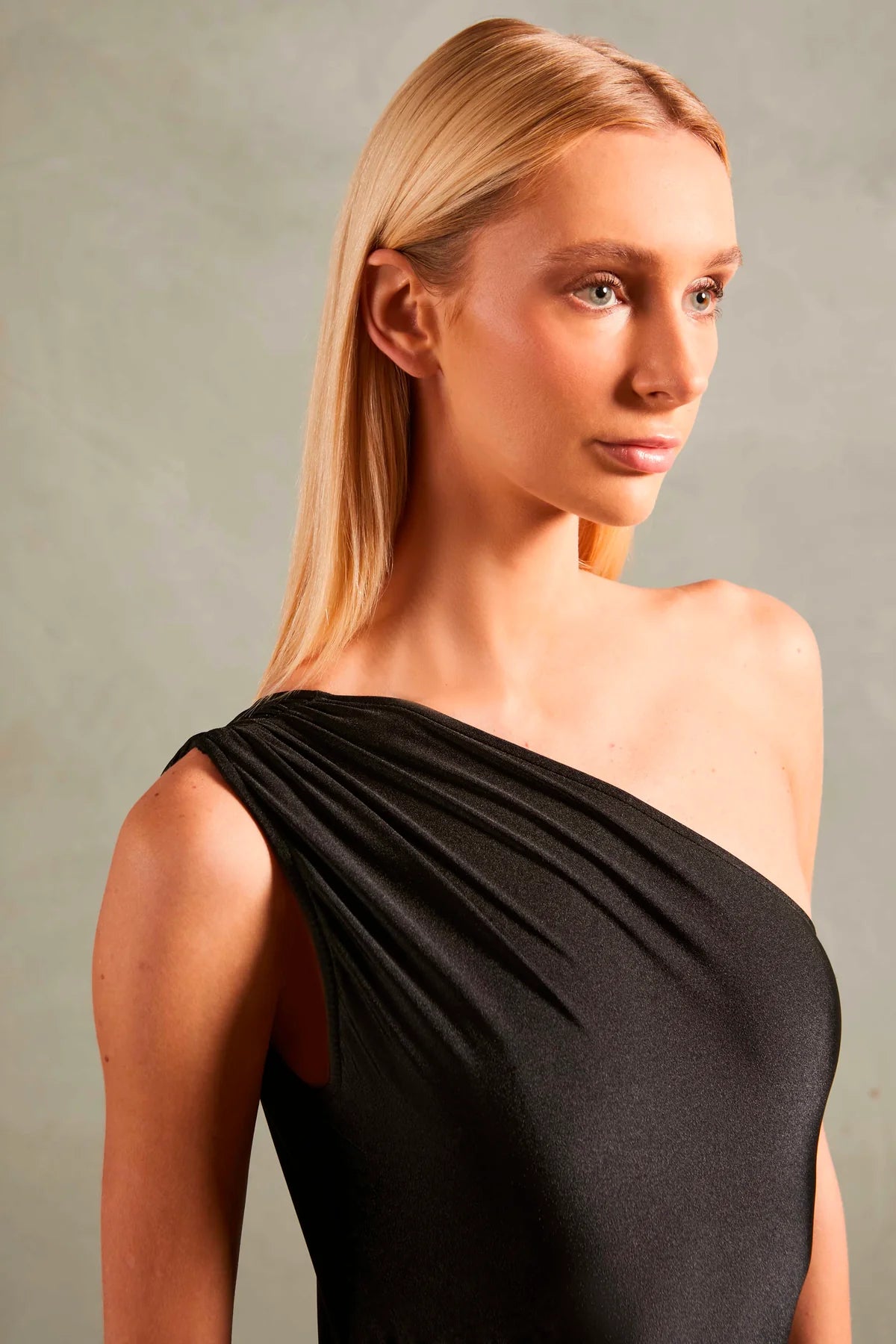 Model wearing the Timeless One Shoulder Swimsuit detail color black with 85% POLYAMIDE 15% SPANDEX fabric for a beachwear look