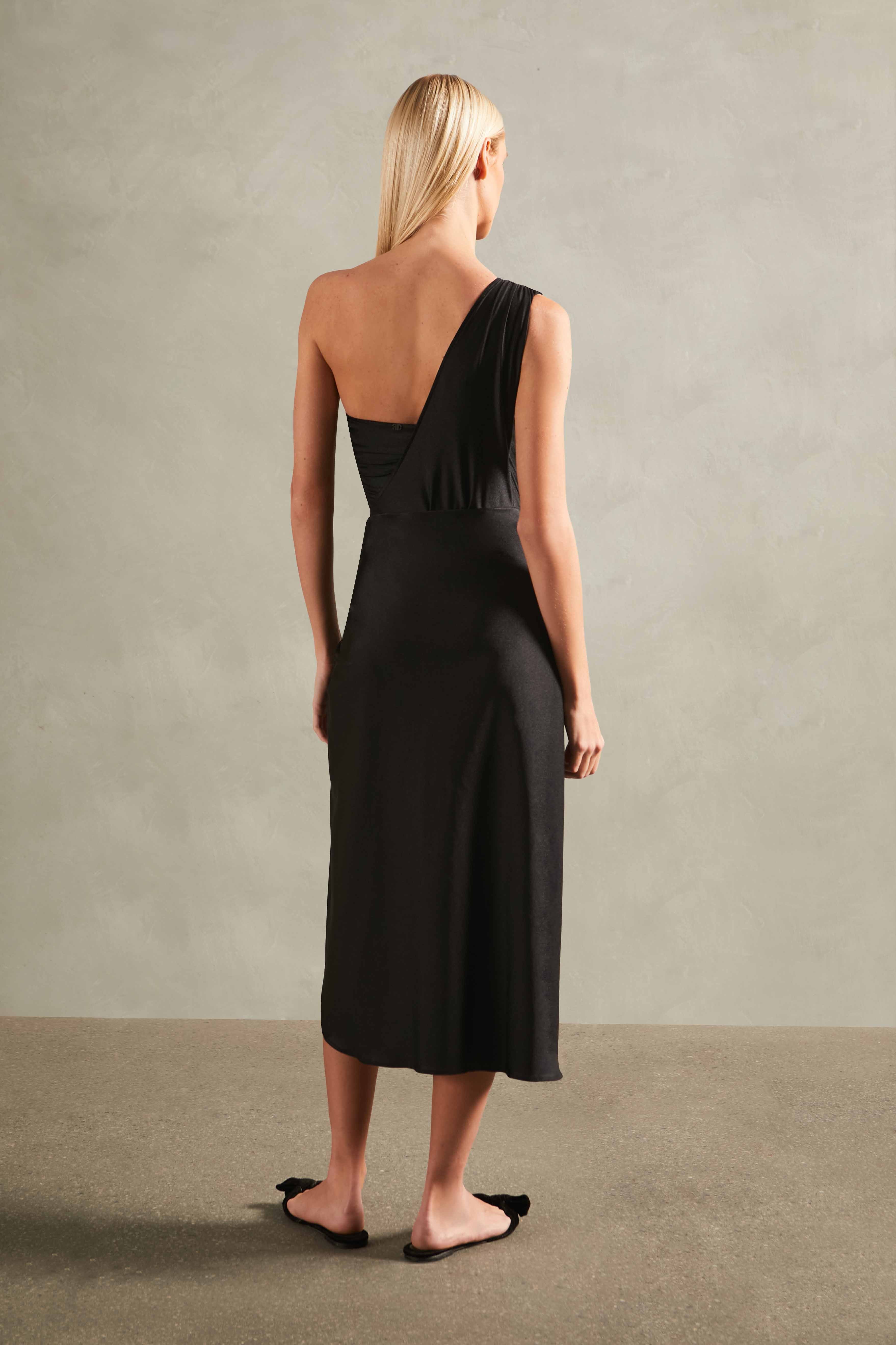 Model wearing the Timeless Pareo Skirt Front back color black with 85% POLYAMIDE 15% SPANDEX fabric styled for a resortwear look