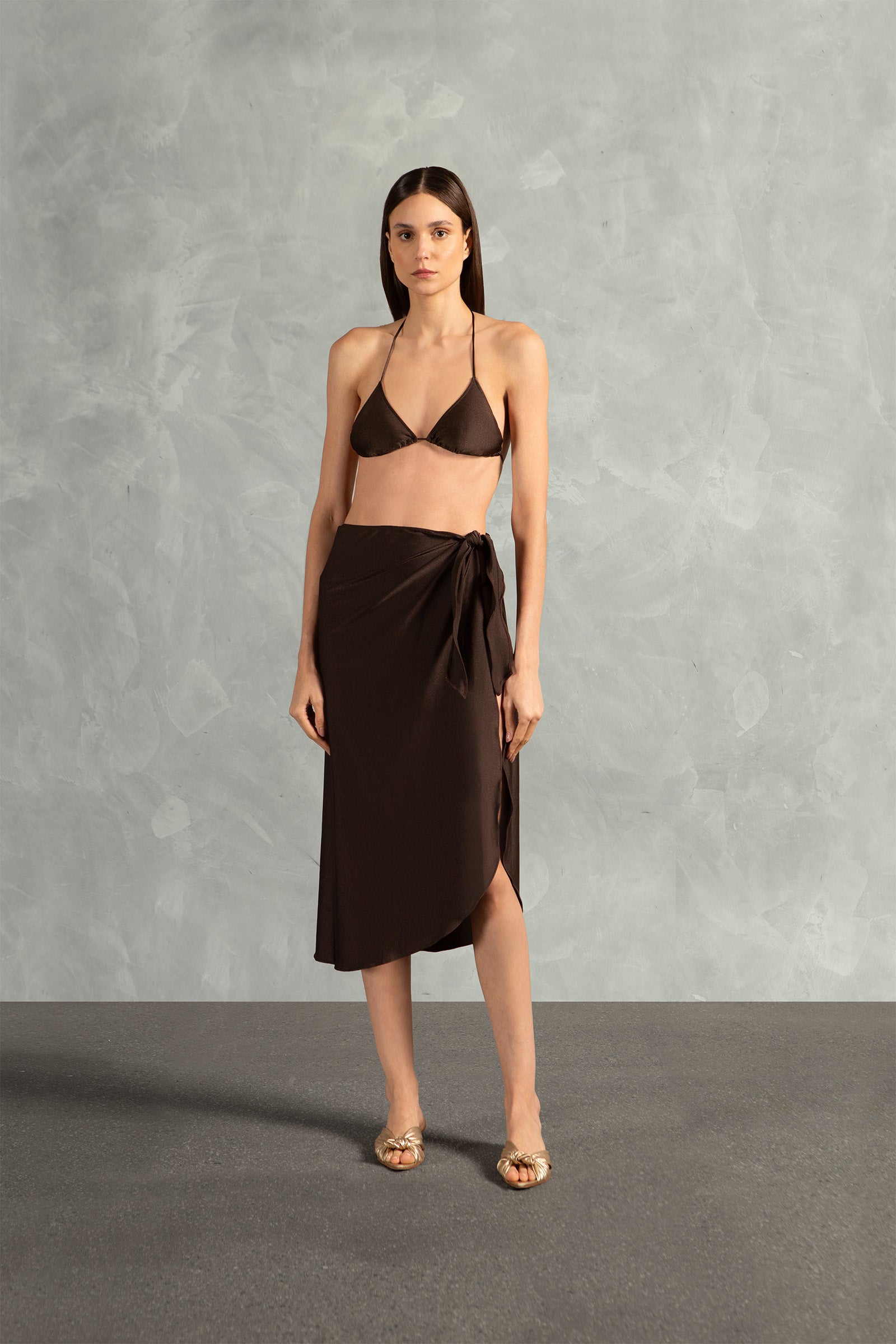 Model wearing the Timeless Pareo Skirt Front color coffee with 85% POLYAMIDE 15% SPANDEX fabric styled for a resortwear look