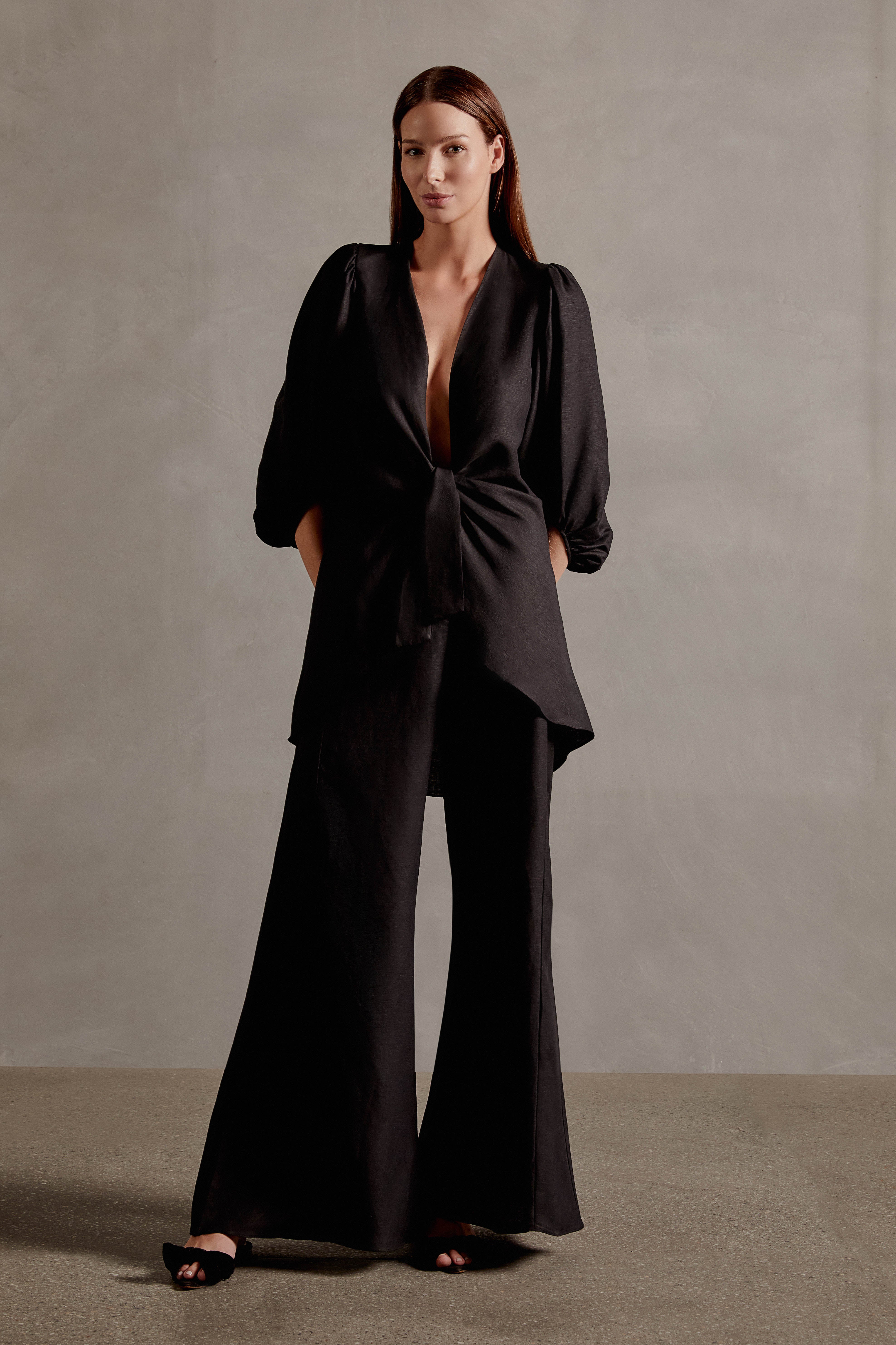 Model wearing the Timeless Wide-Leg Pants color black on 55% VISCOSE 45% LINEN fabric, styled for a resort look.