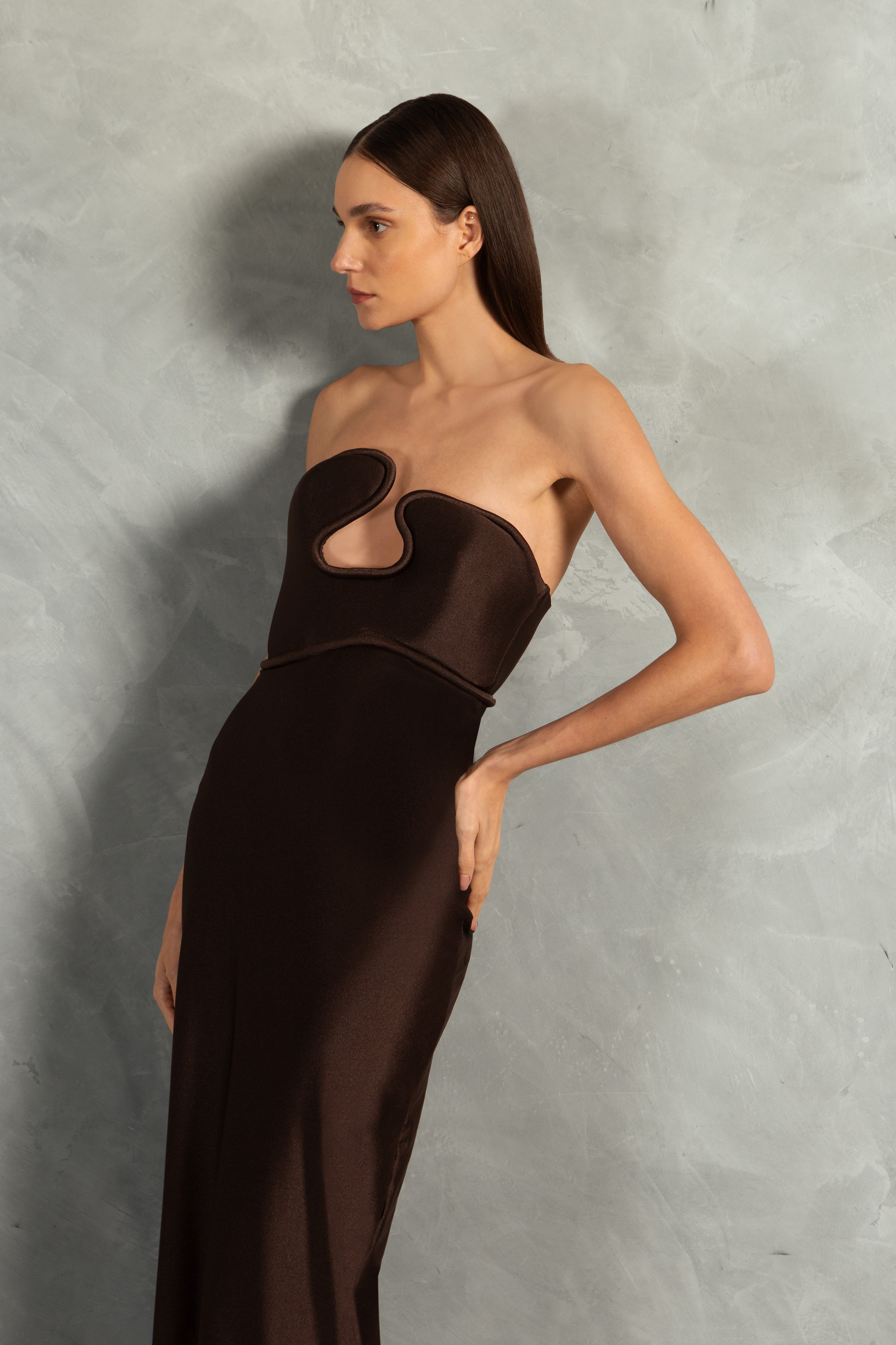 Model wearing the Waves Strapless Long Dress Detail showcasing its Coffee color on 85% Polyamide 15% Elastane fabric, styled for a evening look.