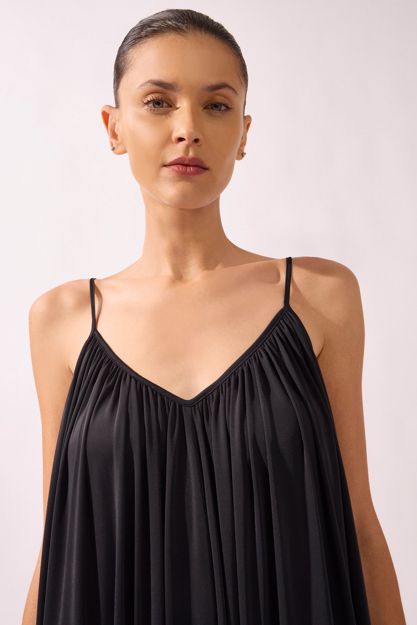 Model wearing the Wide Jersey Jumpsuit detail color black, made from 85% polyamide 15% elastane, styled for a beachwear look