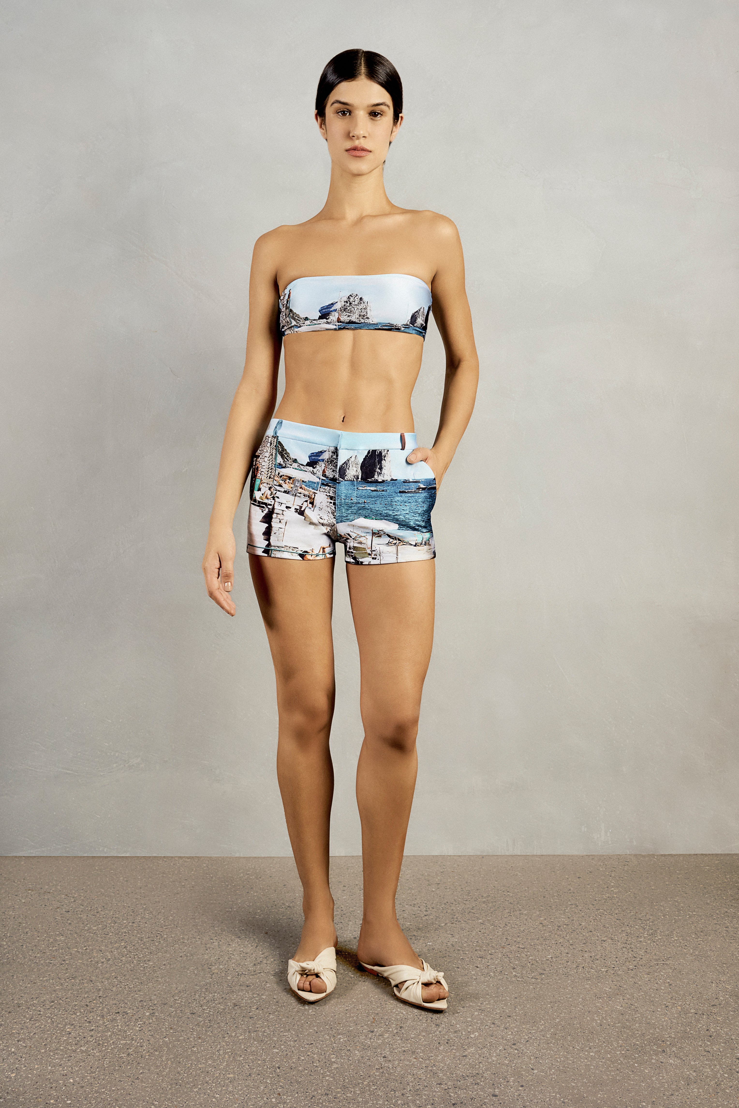 Front view of Adriana Degreas' Postcard Genderless Shorts in a vibrant blue postcard print, featuring a low-waist fit and practical pockets.