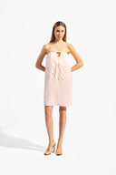 Model wearing the Balearic Mosaic Mini Dress color light pink, made from 100% ramie, styled for a drinks by the pool look