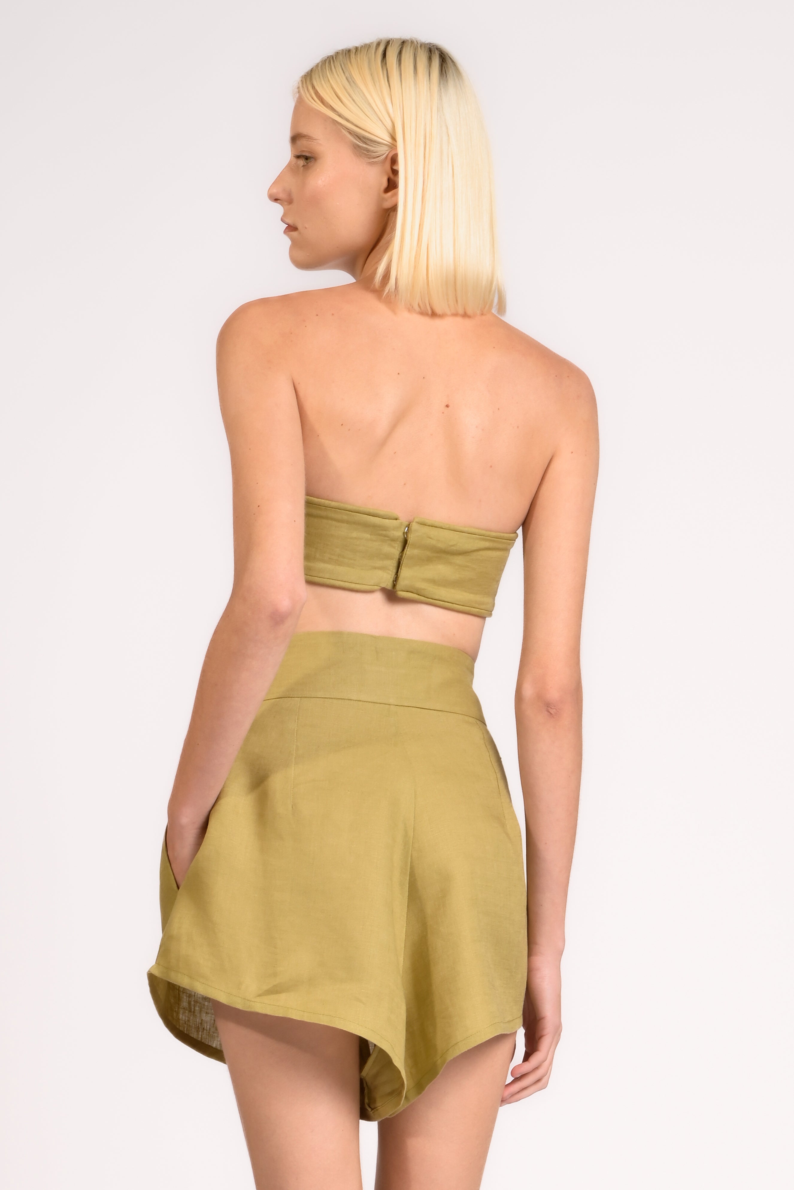 Model wearing the Bandeau Top back color pistachio, made from 100% linen, styled for a resort look