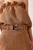 Model wearing the Belted Skort front  detail color brown, made from 55% linen 45% viscose, styled for a resort look
