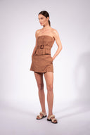 Model wearing the Belted Strapless Top front color cashew yellow, made from 55% linen 45% viscose, styled for a resort look