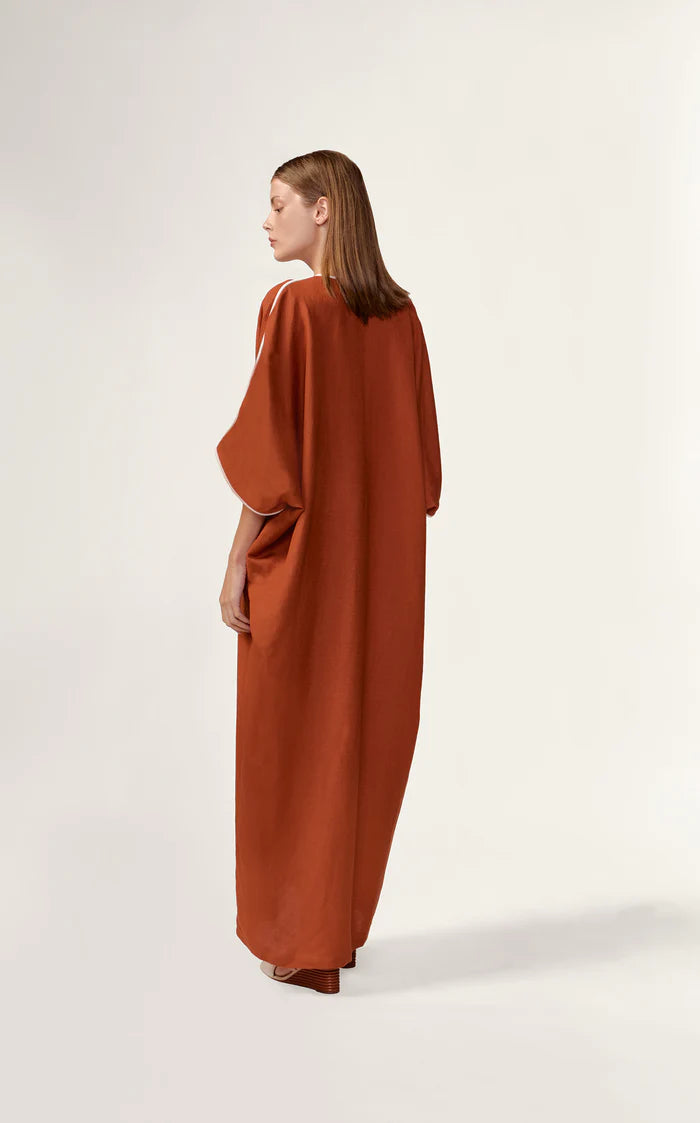 Model wearing the Bicolor Maxi Kaftan back color cognac made with 56% viscose 44% Linen, styled for resortwear look