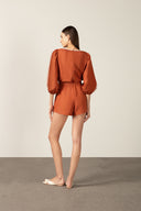 Model wearing the Bicolor V-Neck Romper front color cognac made with 56% viscose 44% Linen, styled for resortwear look
