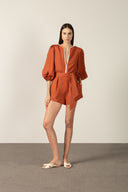 Model wearing the Bicolor V-Neck Romper front color cognac made with 56% viscose 44% Linen, styled for resortwear look