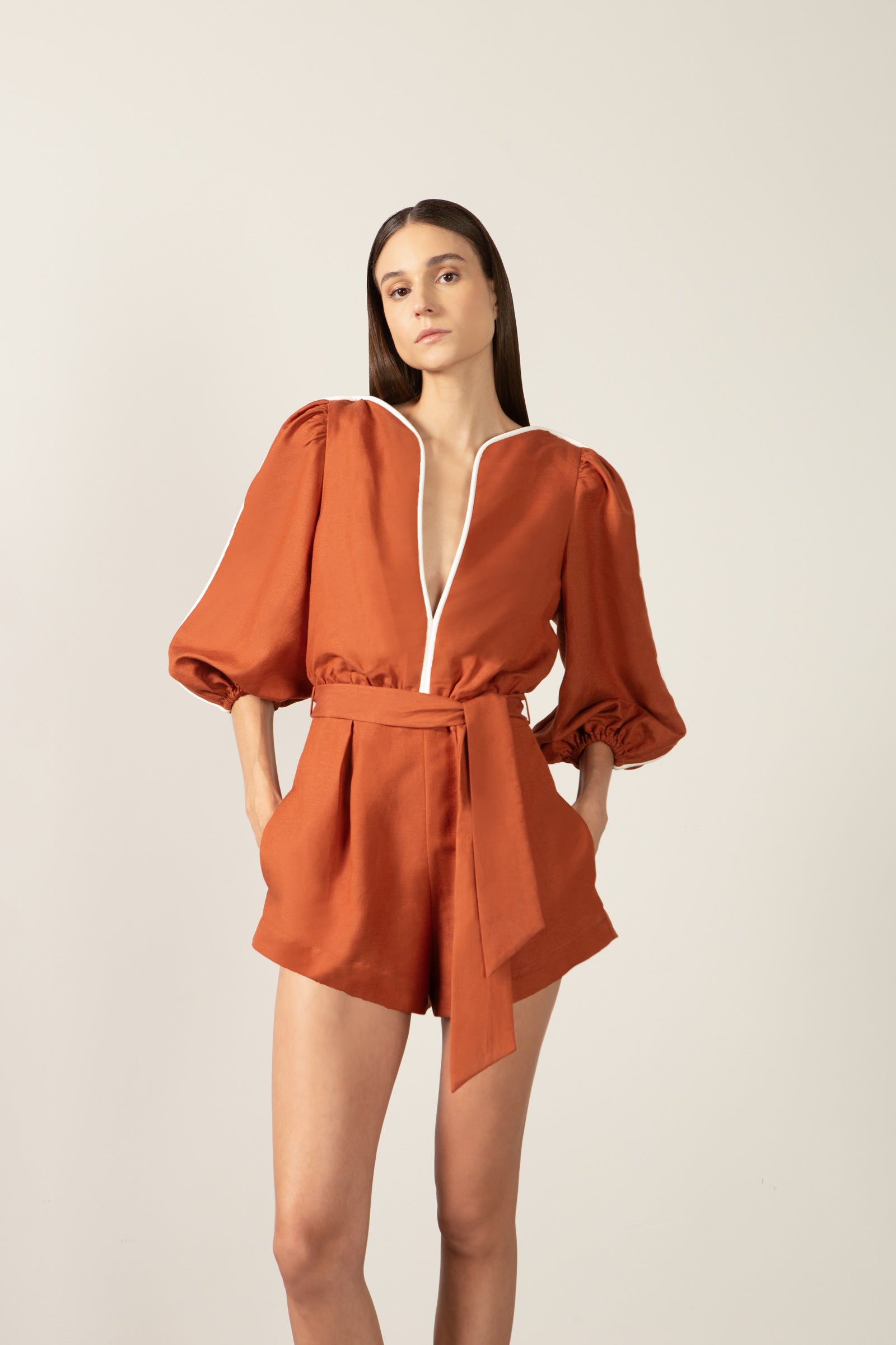 Model wearing the Bicolor V-Neck Romper detail color cognac made with 56% viscose 44% Linen, styled for resortwear look