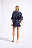 Model wearing the Bicolor V-Neck Romper back color navy made with 56% viscose 44% Linen, styled for resortwear look