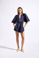 Model wearing the Bicolor V-Neck Romper front color navy made with 56% viscose 44% Linen, styled for resortwear look