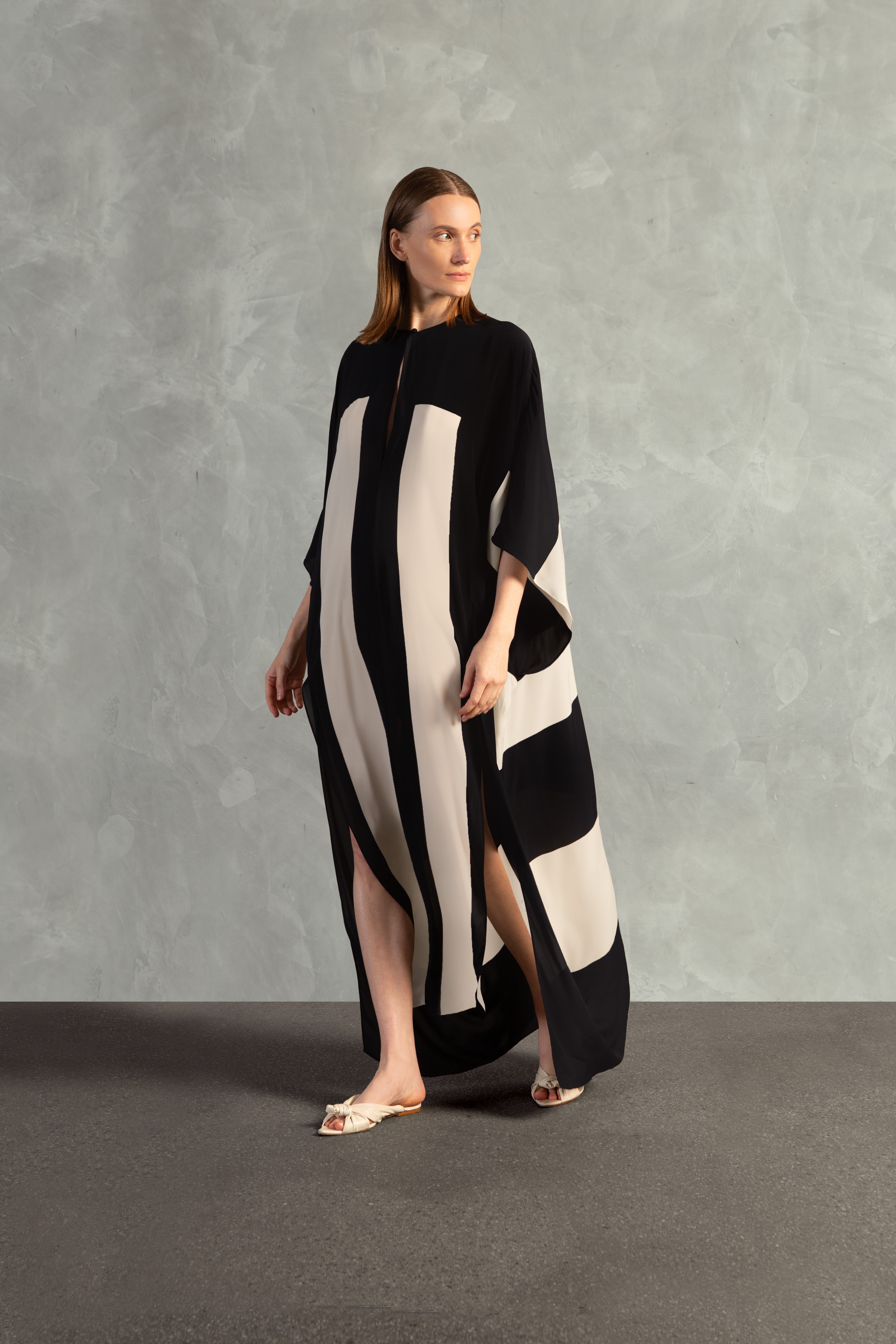 Model wearing the Bold Stripes Long Kaftan Front showcasing its Black print on 100% Viscose fabric, styled for an post-beach look.