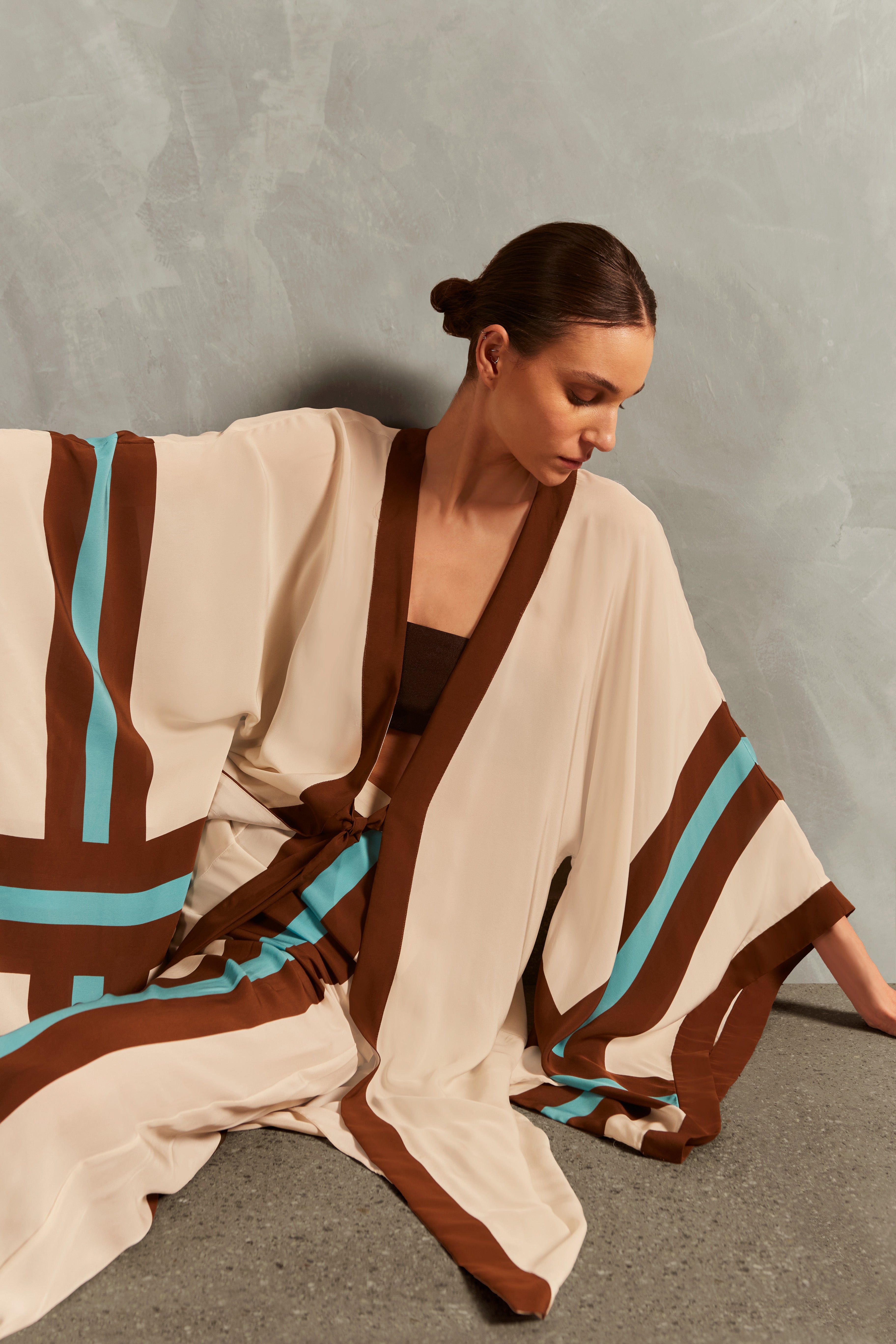 Model wearing the Bold Stripes Maxi Short Robe Concept showcasing its Off White, Brown, Turquoise and Blue print on 100% Viscose fabric, styled for an afternoon look.