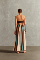 Model wearing the Bold Stripes Wide-Leg Pants Back  showcasing its Off White/Brown/Turquoise Blue print on 100% Viscose fabric, styled for an afternoon look.
