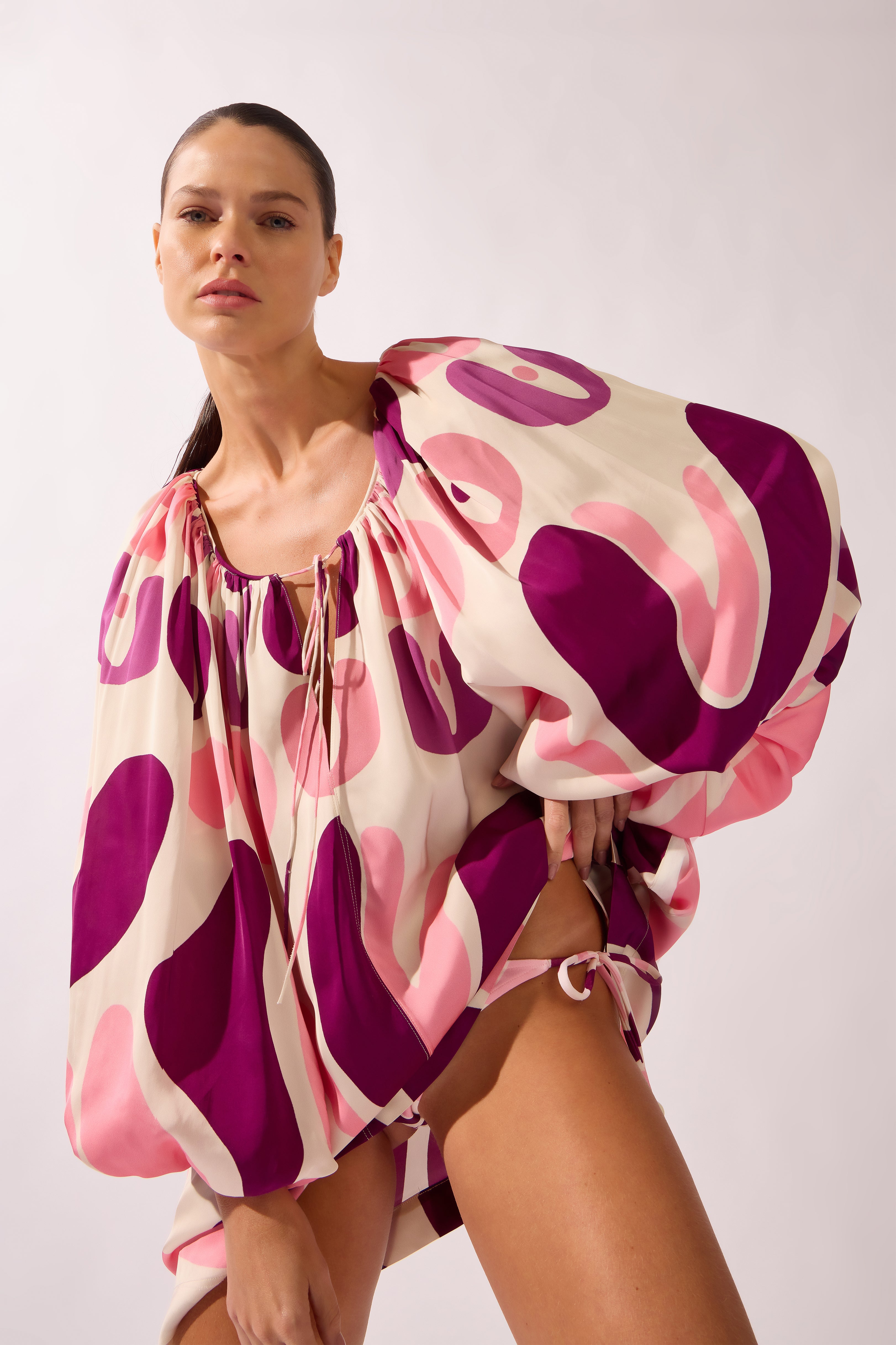 Model wearing the Bold Floral Puff Sleeve Mini Dress detail color unique, made from 100% viscose, styled for a beachwear look