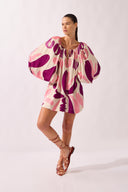 Model wearing the Bold Floral Puff Sleeve Mini Dress look color unique, made from 100% viscose, styled for a beachwear look