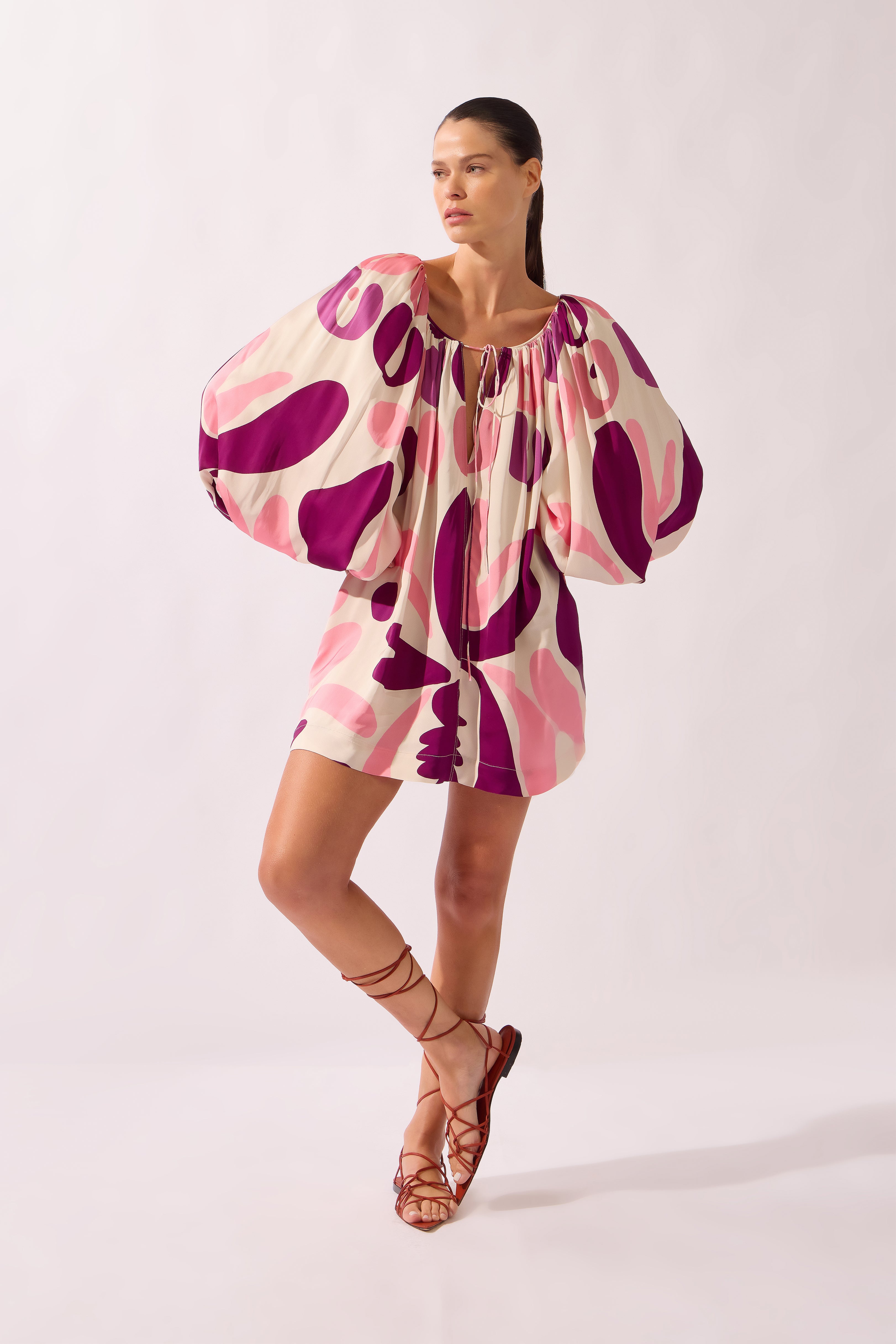 Model wearing the Bold Floral Puff Sleeve Mini Dress look color unique, made from 100% viscose, styled for a beachwear look