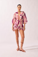 Model wearing the Bold Floral Shirt front color unique, made from 75% Lyocell 25% Polyester, styled for a beachwear look