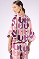 Model wearing the Bold Floral Wide-Leg Pants back detail color unique, made from 100% viscose, styled for a resort look