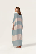Model wearing the Bold Stripes Maxi Kaftan back showcasing its blue print on 100% Viscose fabric, styled for an post-beach look.