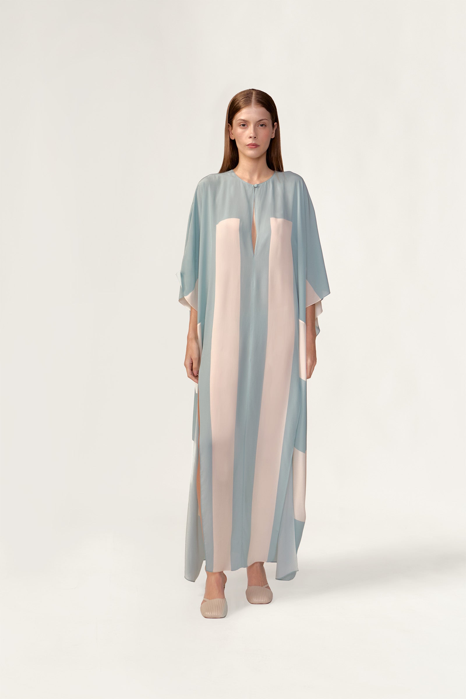 Model wearing the Bold Stripes Maxi Kaftan front showcasing its blue print on 100% Viscose fabric, styled for an post-beach look.