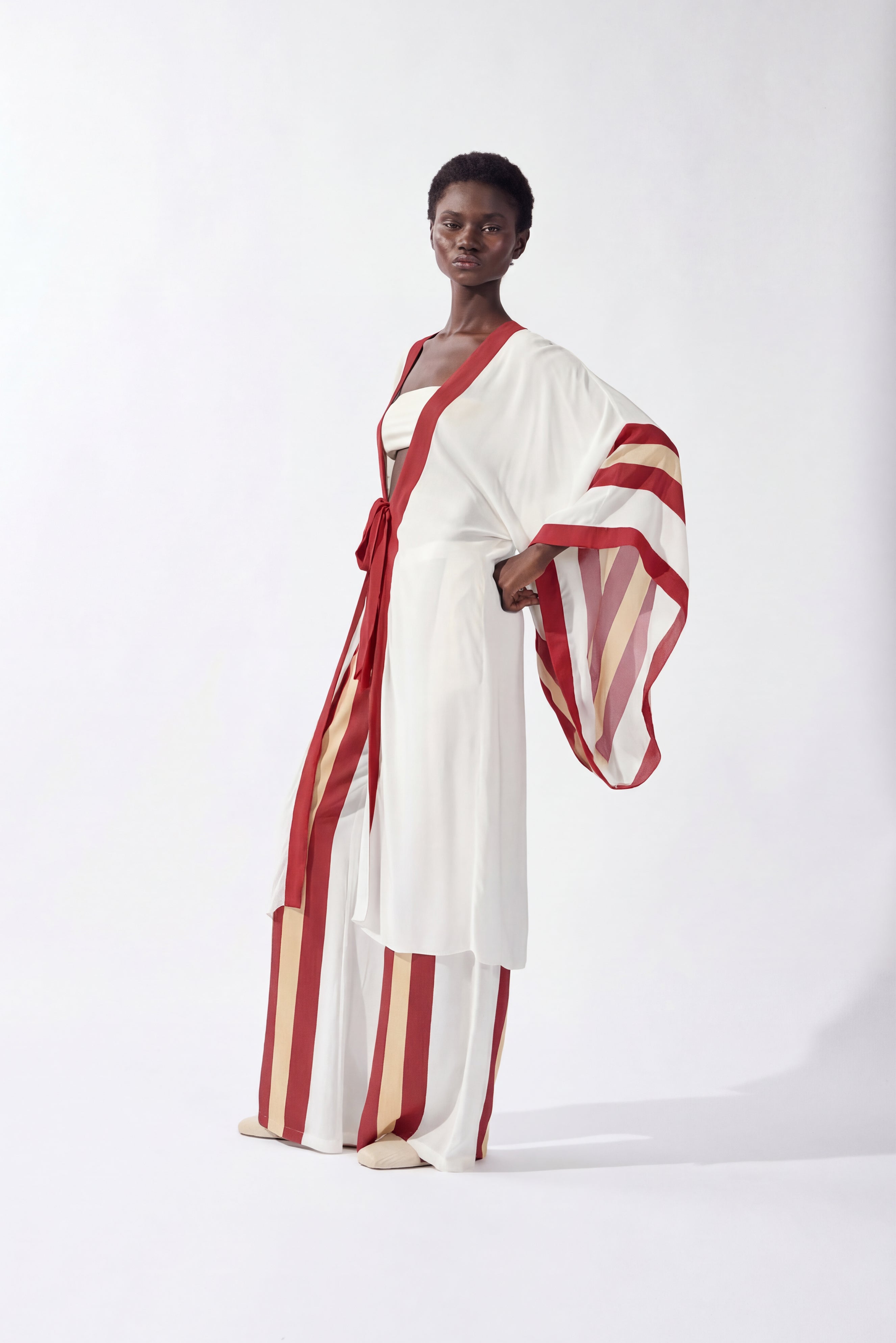 Model wearing the Bold Stripes Robe front, color off white, burgundy, beige, made from 100% viscose, styled for a resort look