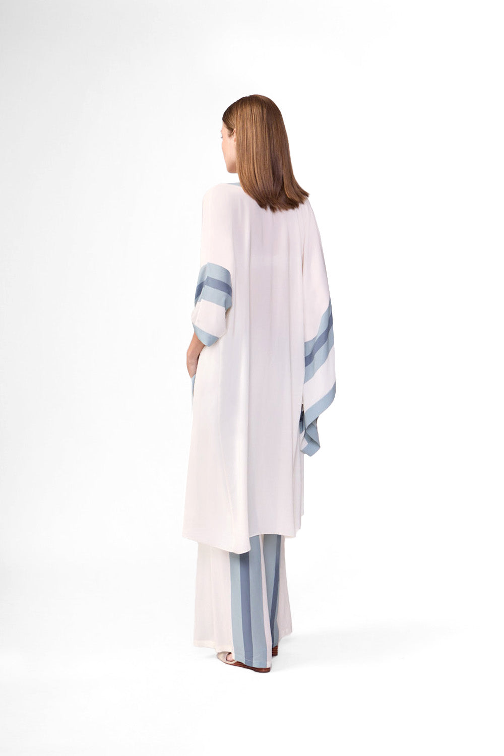 Model wearing the Bold Stripes Wide-Leg Pants back color off white and light blue color, made with 100% viscose, styled for resortwear look